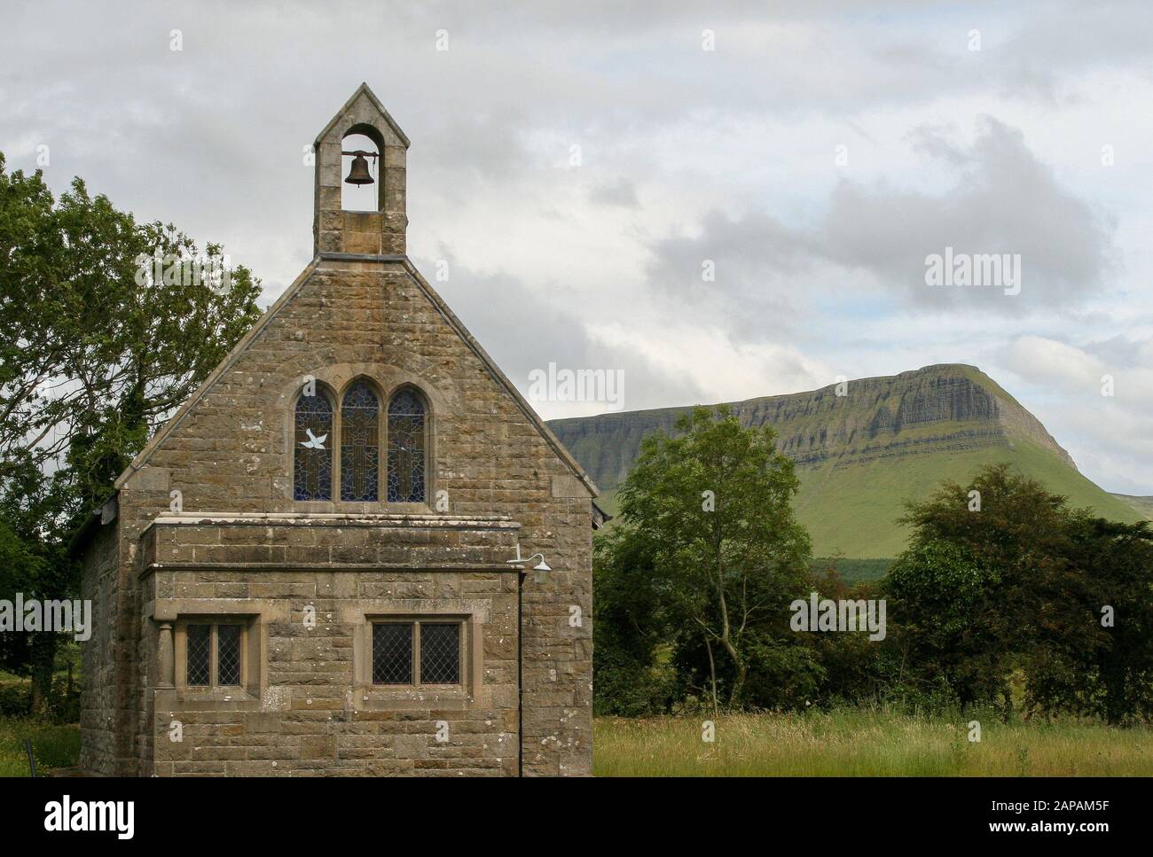Ländliche Pfarrkirche mit einer Glocke in Irland vor einem Berg. St. Kevin's Munninane ist eine Gemeinde der irischen Pfarrei neben Benbulben im County Sligo. Stockfoto