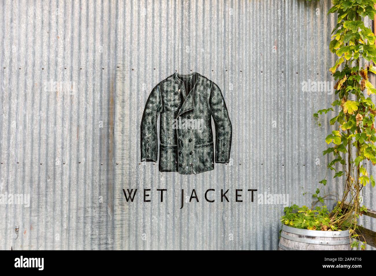 Wet Jacket Weingut Logo und Weinstock an der Seite des Metallgebäudes Stockfoto