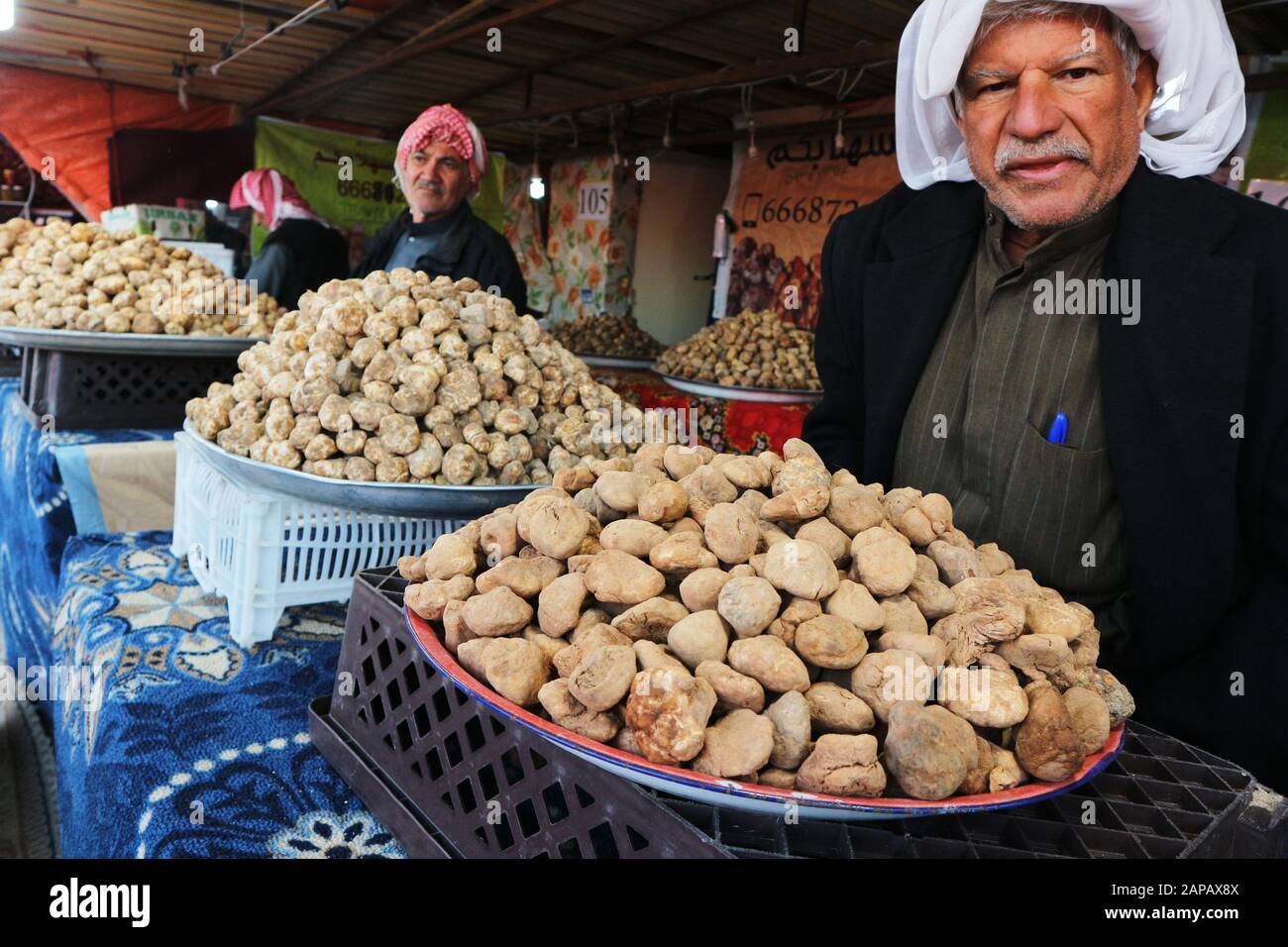 Kuwait-Stadt/Kuwait - 10. Januar 2020: Arabischer Mann im traditionellen Kopfkleid, der Wüstentrüffel verkauft Stockfoto