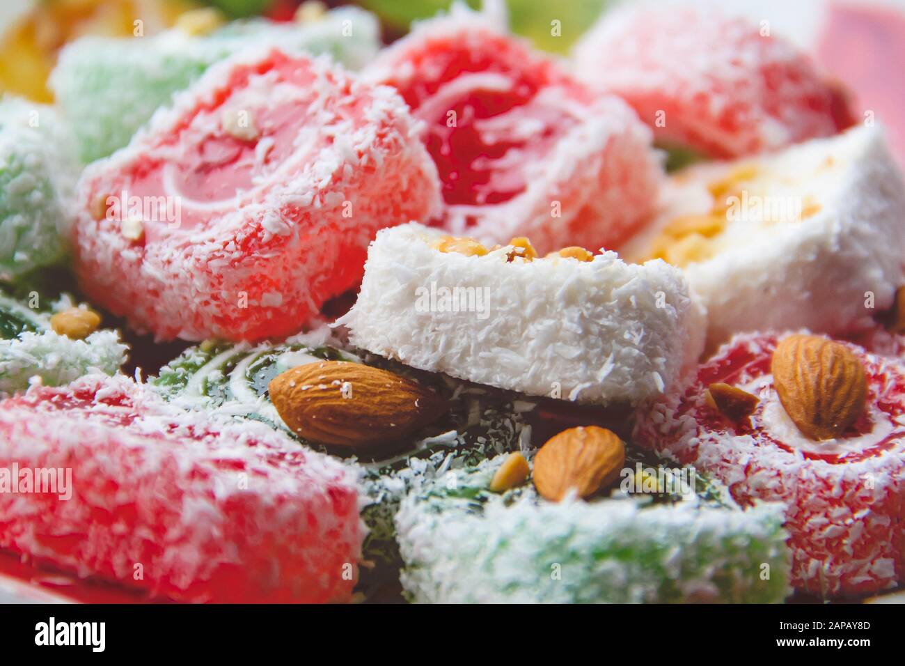 Nahaufnahme von Süßigkeiten türkische Köstlichkeiten. Rote türkische Freude von Rot, Weiß und Grün mit Mandelnüssen. Fotografie von Desserts. Stockfoto