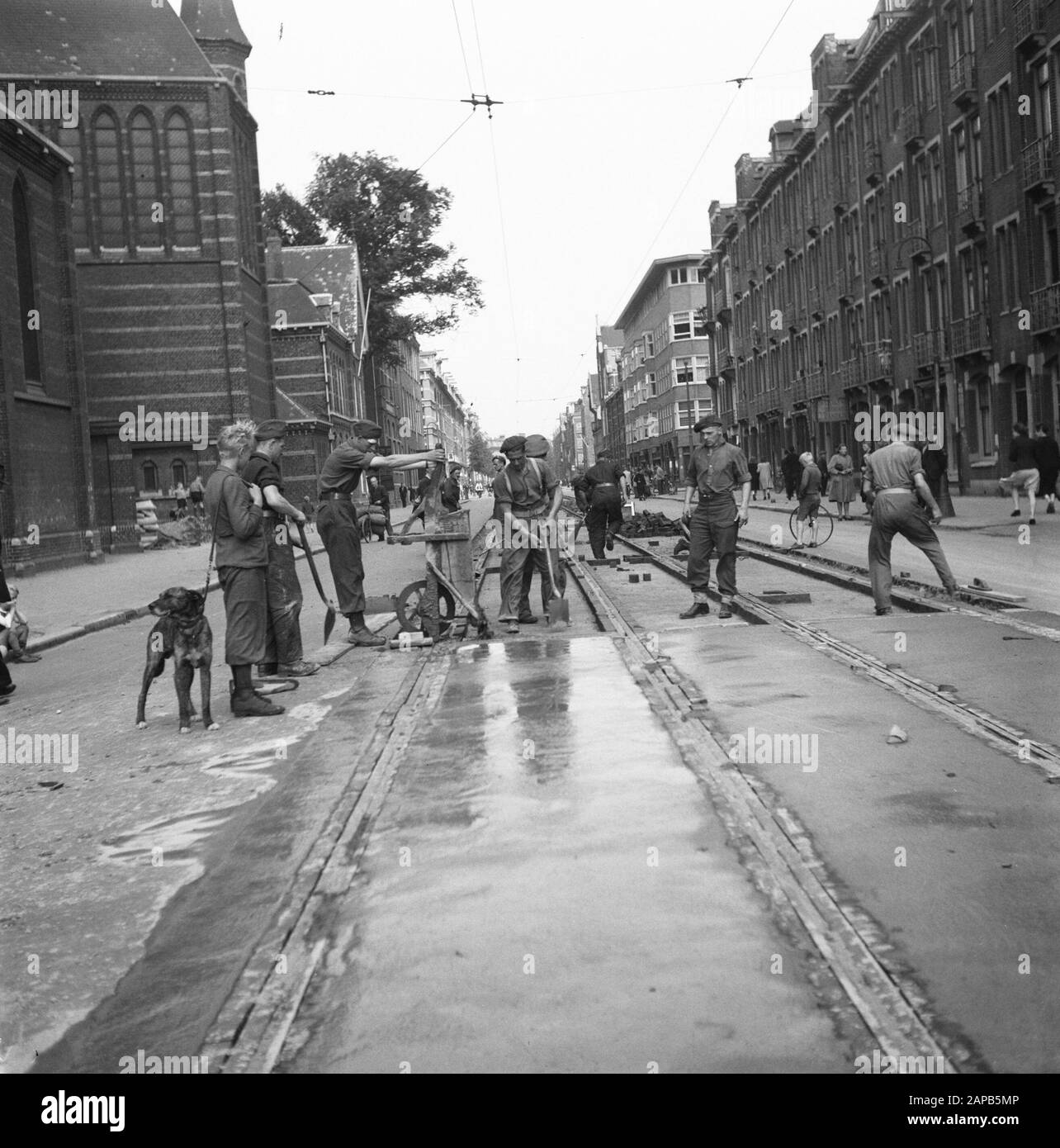 Recovery: Amsterdam Beschreibung: Amsterdam. Spaarndammerstraat in der Nähe der Maria-Magdalena-Kirche. Unter der Führung des Kapitäns J. Breman begann die 2nd Genie Company in Amsterdam mit der Reparatur von sehr weitreichenden Arbeiten. Seine Aufgabe ist es, alle Verkehrshindernisse in der Stadt Amsterdam so schnell wie möglich zu beseitigen, einschließlich der Räumung von Bauarbeiten im Hafen. Die Arbeit besteht auch darin, Barrieren zu beseitigen, die von den Deutschen in den Straßen hergestellt wurden, und die durch Holzblöcke verursachten Verkaperungen zu schließen: Überflutete Keller zu pumpen usw. Anmerkung: Das Kirchengebäude des Architekten P.J.H. Cuypers wurde eingerissen Stockfoto