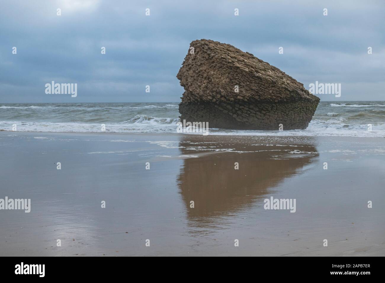 Der Felsen, Teil eines alten, auf dem Kopf stehenden Turms (Torre de la Higuera) am Strand in Matalascañas, Huelva, Spanien. Stockfoto