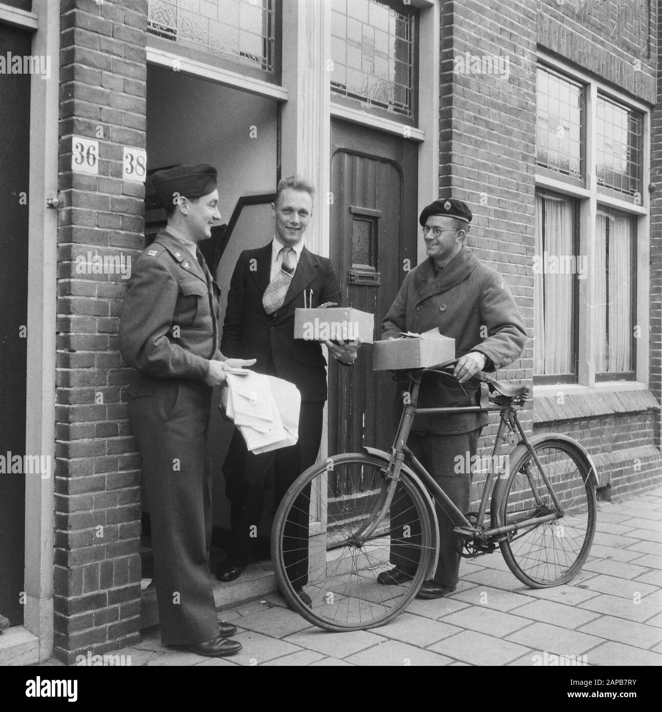 Angloamerikanischer Dank. Während des Krieges schützten viele niederländische Soldaten alliierte Piloten, die über die Niederlande geschossen wurden, und arbeiteten an ihrer Rückkehr zu den alliierten Linien. Viele stellten dann ihre Fahrräder, Kleidung usw. zur Verfügung, die sie nun von den englischen und amerikanischen Missionen hier erhalten. Kapitän Frank Coslett und Leutnant Rombout überraschen einen illegalen Helfer aus der Besatzungszeit mit einem Fahrrad (Reifenpanne oder leere Reifen beachten) und Textilwaren Datum: November 1945 Schlagwörter: Fahrräder, Geschenke, Weltkrieg, Resistance Personname: Coslett Frank Stockfoto