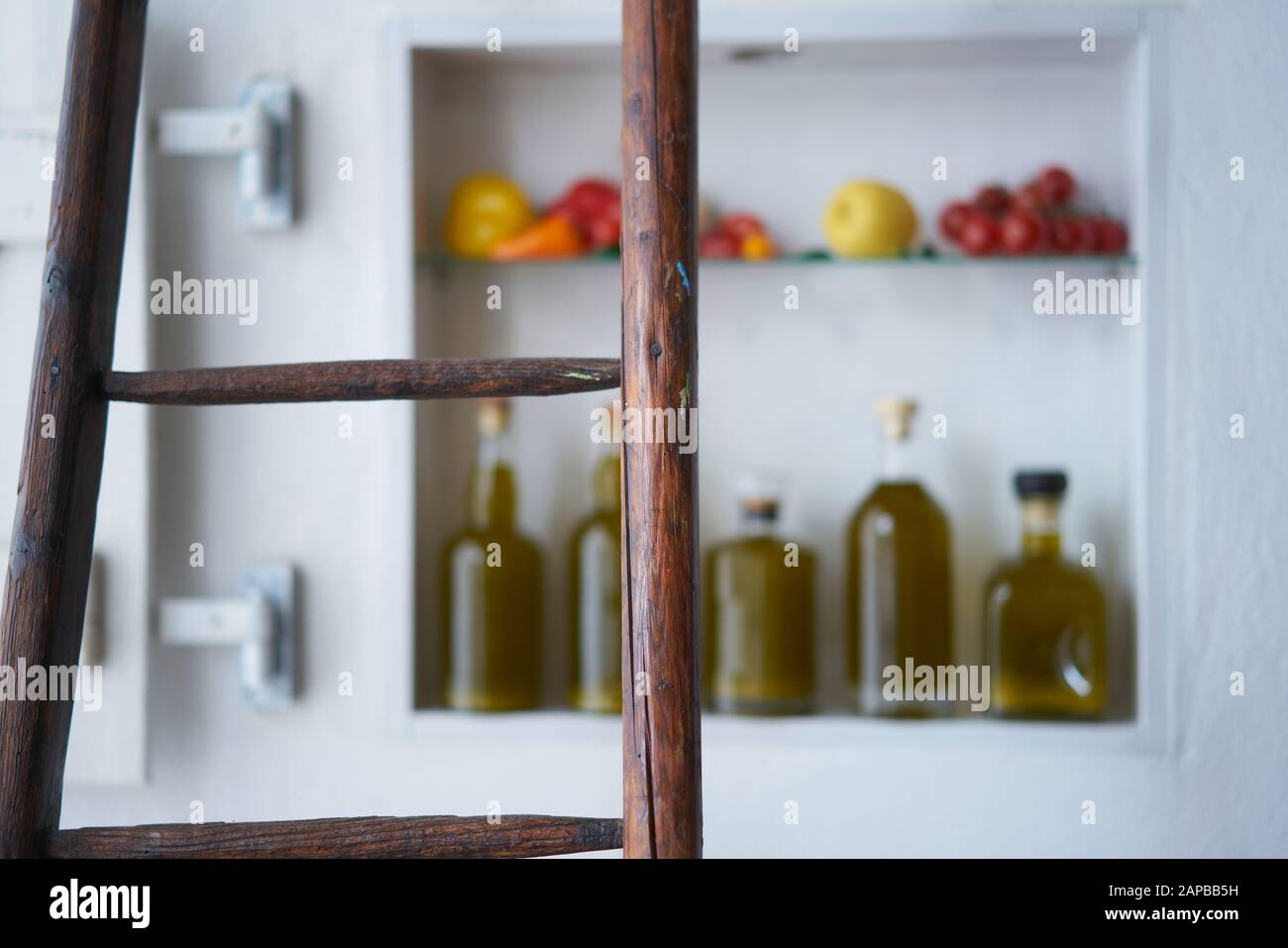 Nahaufnahme von einer Holzleiter mit verschwommenem diffusem Hintergrund in einem kleinen Ladenhaus, Hausküche im mediterranen Stil Stockfoto