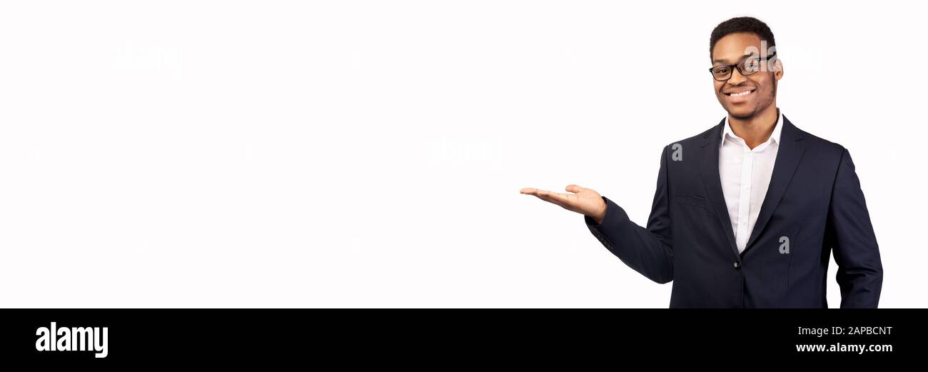 Lächelnder schwarzer Mann mit seiner Handfläche über weißem Hintergrund Stockfoto