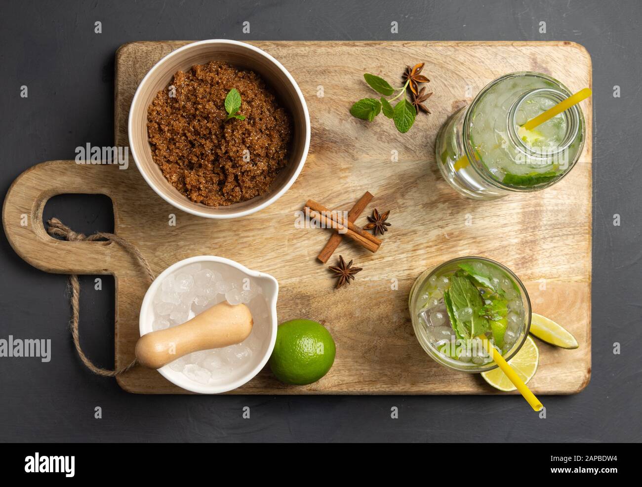 Caipirinha, Limette, frische Minze, brauner Zucker und zerkleinertes Eis. Rustikale Umgebung mit schwarzem Hintergrund. Luftansicht Stockfoto