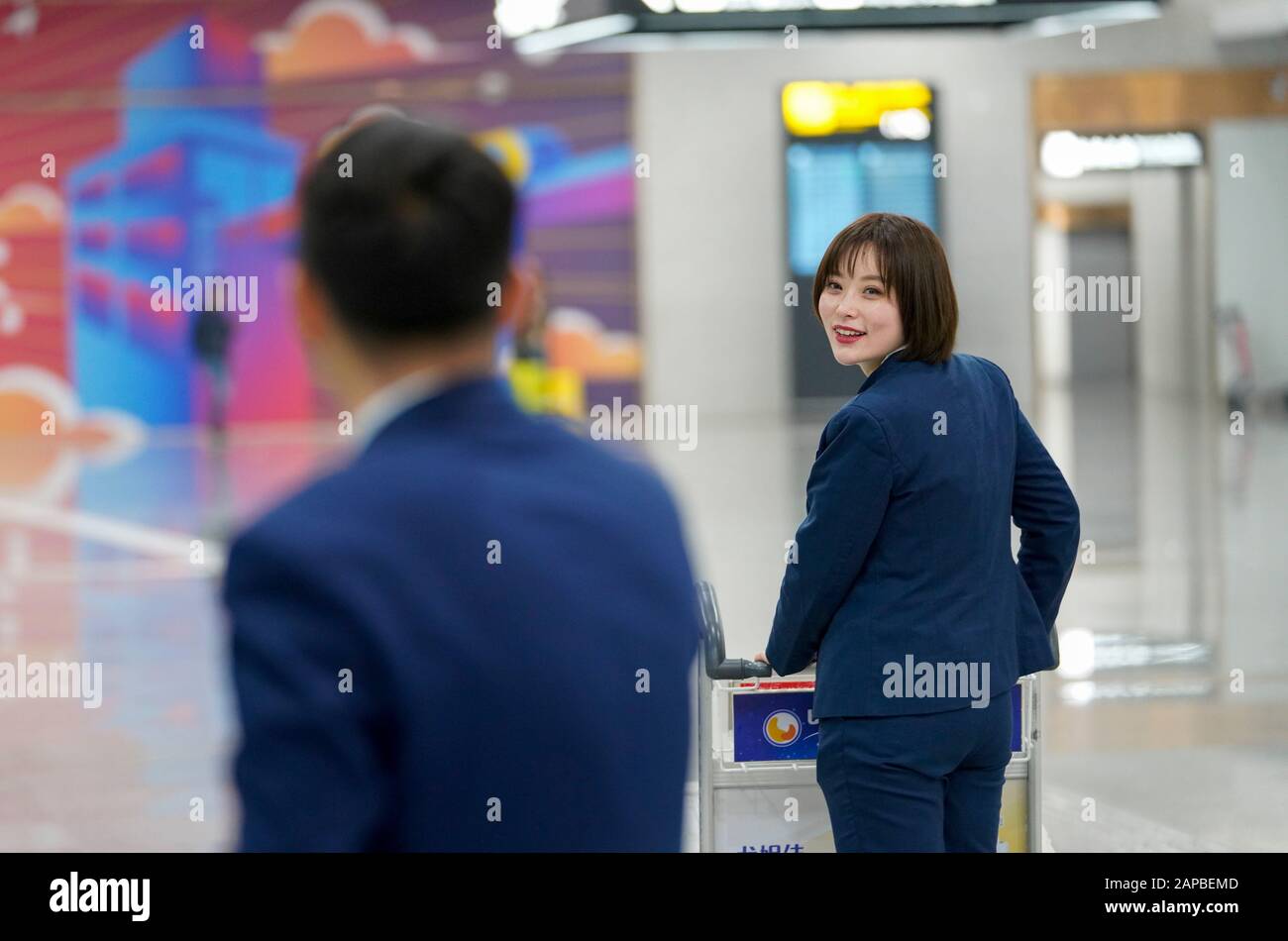 (200122) -- CHONGQING, 22. Januar 2020 (Xinhua) -- Yang Meng wendet sich um, um ihren Ehemann Dai Chong daran zu erinnern, mehr Wasser im T3A Terminal des Chongqing Jiangbei International Airport im Südwesten Chinas Chongqing, 22. Januar 2020, zu trinken. Das Jahr 2020 ist der 10. Frühlingsfestival, der für das Paar Dai Chong und Yang Meng anstürme, die sich in diesem Zeitraum nur zehn Minuten täglich sehen können. Beide arbeiten für den Bodendienst am internationalen Flughafen Chongqing Jiangbei, wobei einer als Check-In-Schalter und der andere als Servicemitarbeiter arbeitet. Beschäftigt mit der Bedienung der Passa Stockfoto