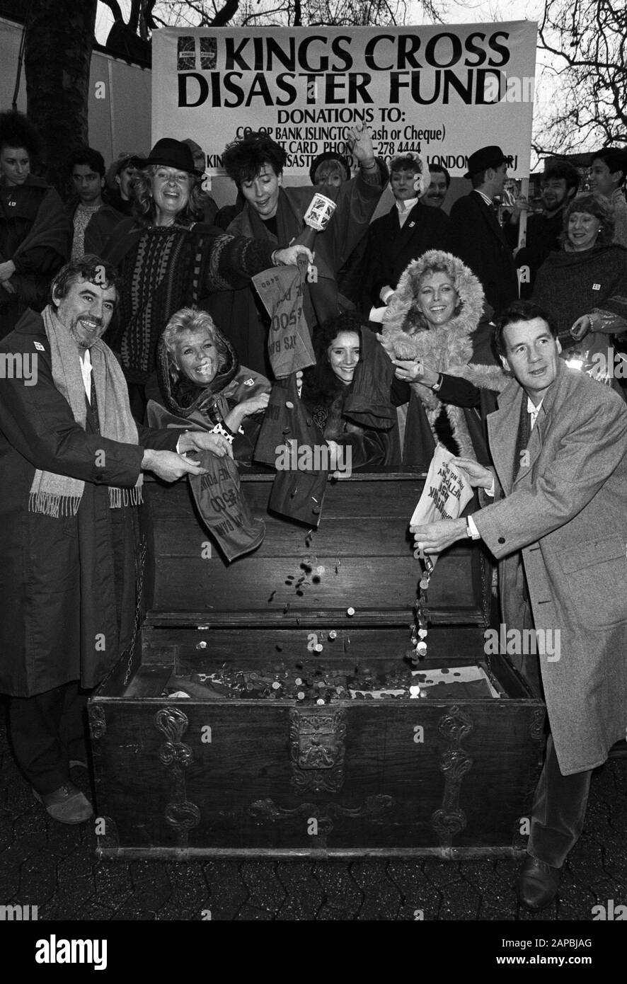 Zeigen Sie Business-Stars, die dabei helfen, die Kassen des Kings Cross Disaster Fund bei einer Karol-Singsitzung am Leicester Square in London zu füllen. (Vorne, L-R) Terry Jones, Judith Chalmers, Sarah Pickering, Billie Whitelaw und Michael Palin. Dahinter steckt die TV-Schauspielerinnen Anna Cateret (mit umkrempeltem Hut) leert ihre Tasche und Emma Thompson hält eine Sammelbox (Mitte), im Hintergrund die Besetzung von "Kiss Me Kate". Stockfoto