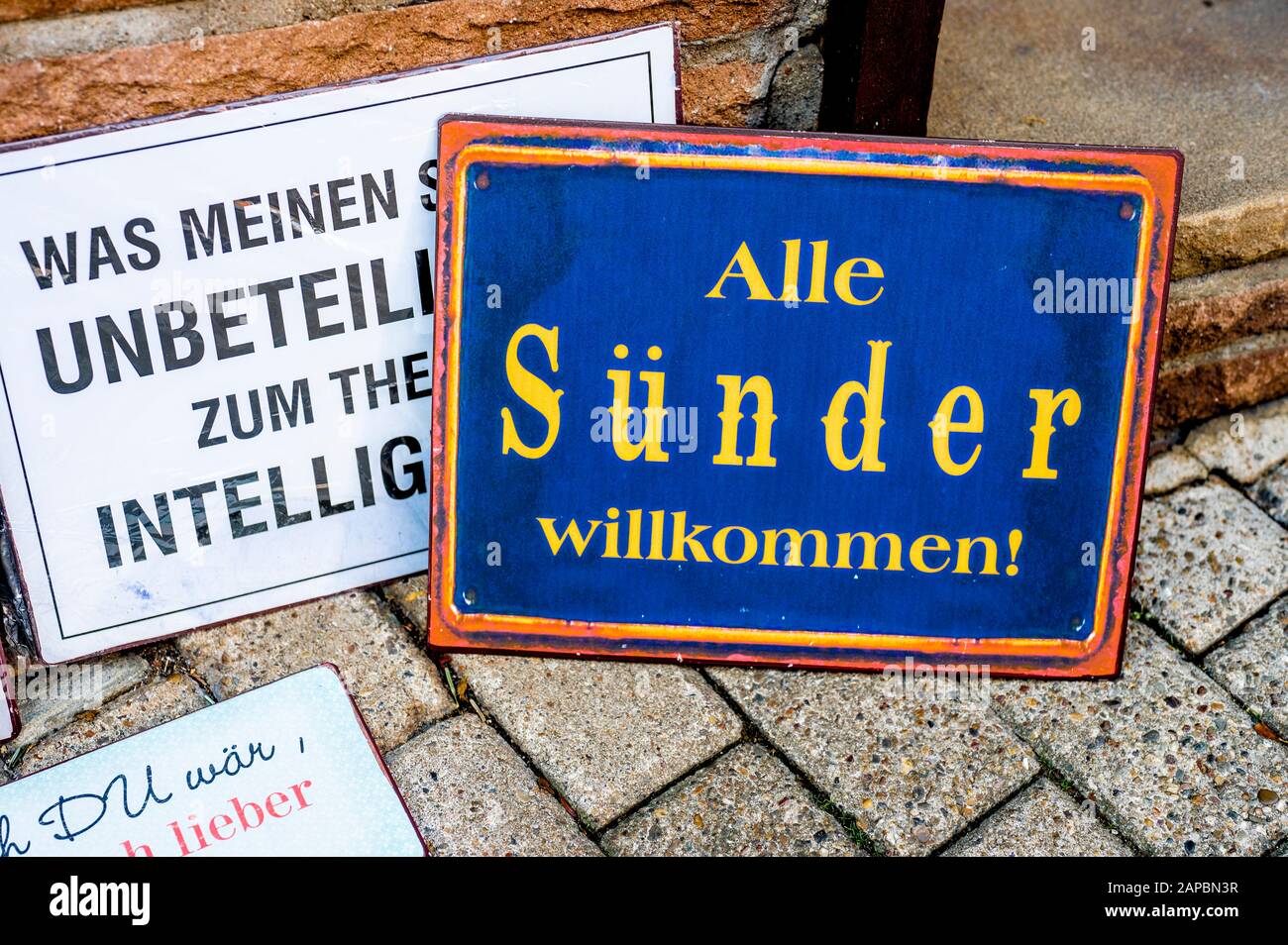 Lustige Sprüche auf Tellern auf dem Display; Humorvolle Sprüche Auf Ausgestellten Metallplatten Vor Einem laden Stockfoto