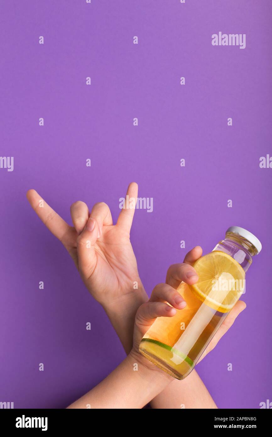 Frau mit Hornschild und Flasche mit köstlichem Zitronendetox-Wasser Stockfoto