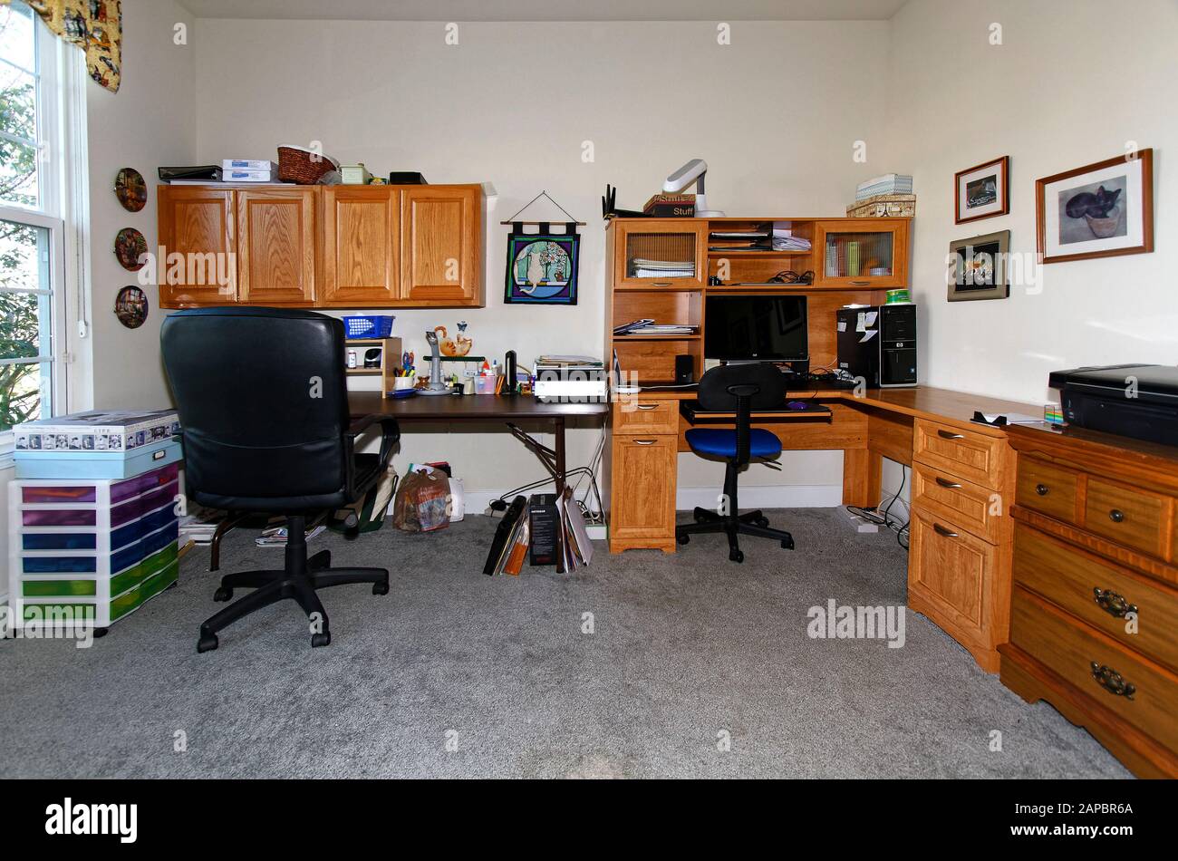 Heimbüro, Schreibtisch in L-Form, Arbeitstisch, Wandschränke, Computer, Stühle, Lampen, Handwerkskunst, Fenster, horizontal; PR Stockfoto