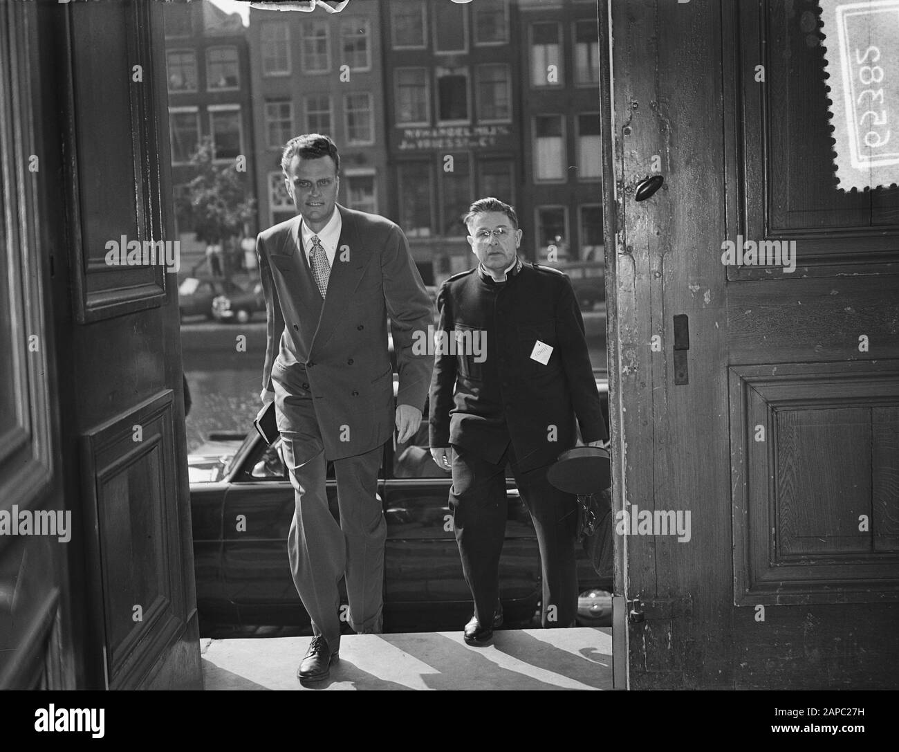 Billy Graham (amerikanischer Evangelist) in den Niederlanden, Ankunft an der Ronde Lutheran Church in Amsterdam Anmerkung: Neben ihm (rechts) sein Übersetzer Major L. Nijman von der Heilsarmee Datum: 22. Juni 1954 Ort: Amsterdam, Noord-Holland Schlüsselwörter: Evangelisten, Kirchen, Religion persönlicher Name: Graham, Billy, Nijman, L. Institutionenname: Lutherse Kerk Stockfoto