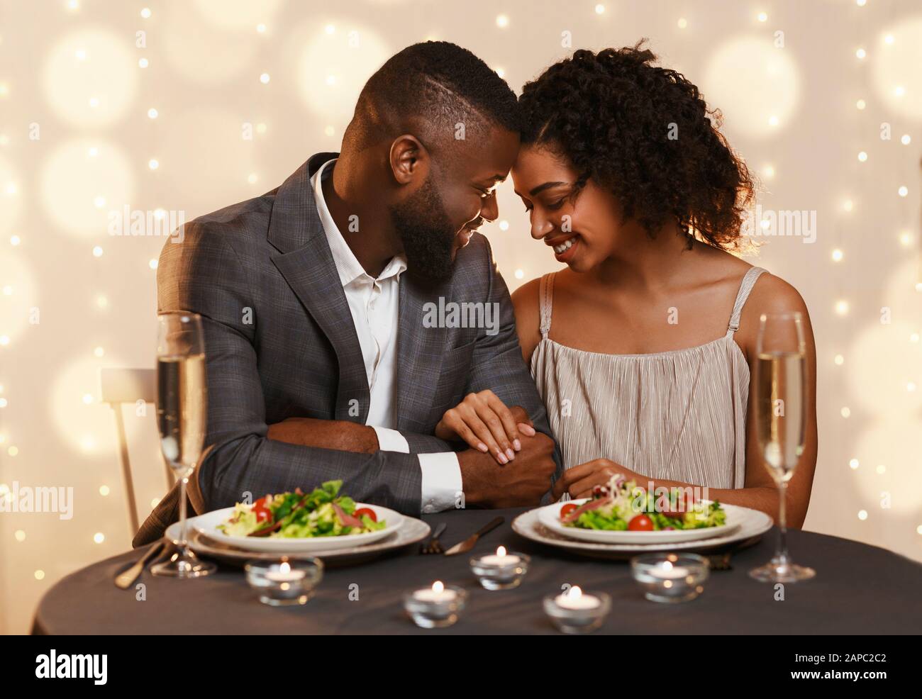 Afrikanisches Paar, das sich beim Abendessen im Restaurant verliebt Stockfoto