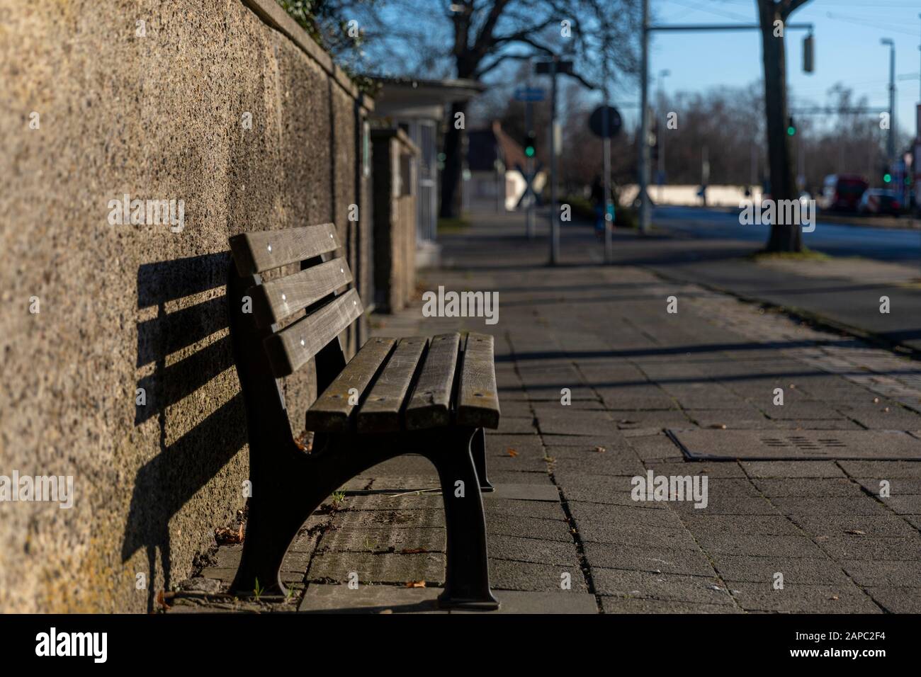 Bank lädt müden Fußgänger in Braunschweiger Wintersonne ein Stockfoto