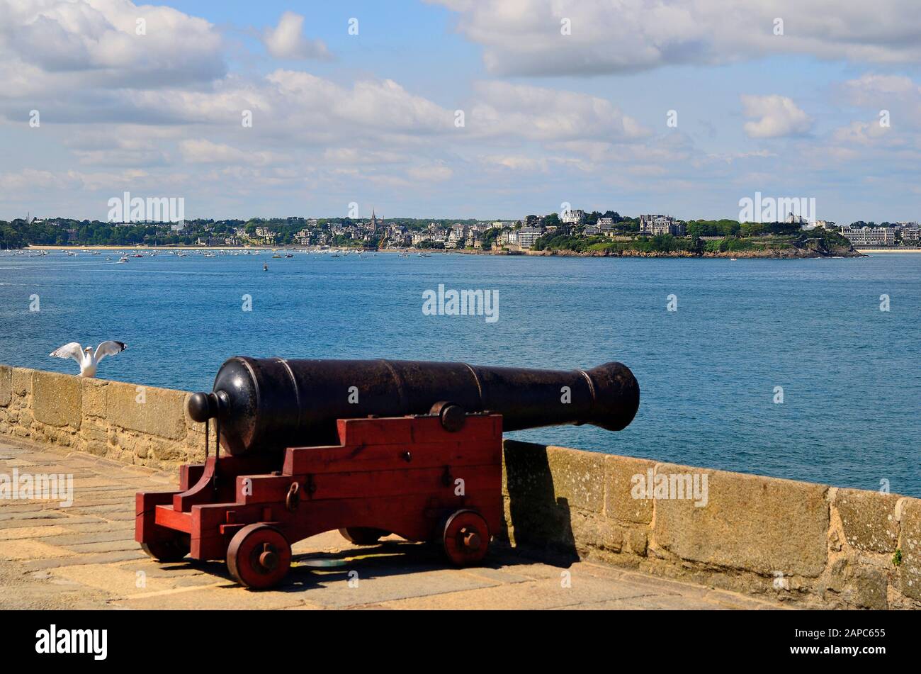 Frankreich, Mittelalterkanone an befestigter Mauer in St. Malo mit Blick auf Dinard Village Stockfoto