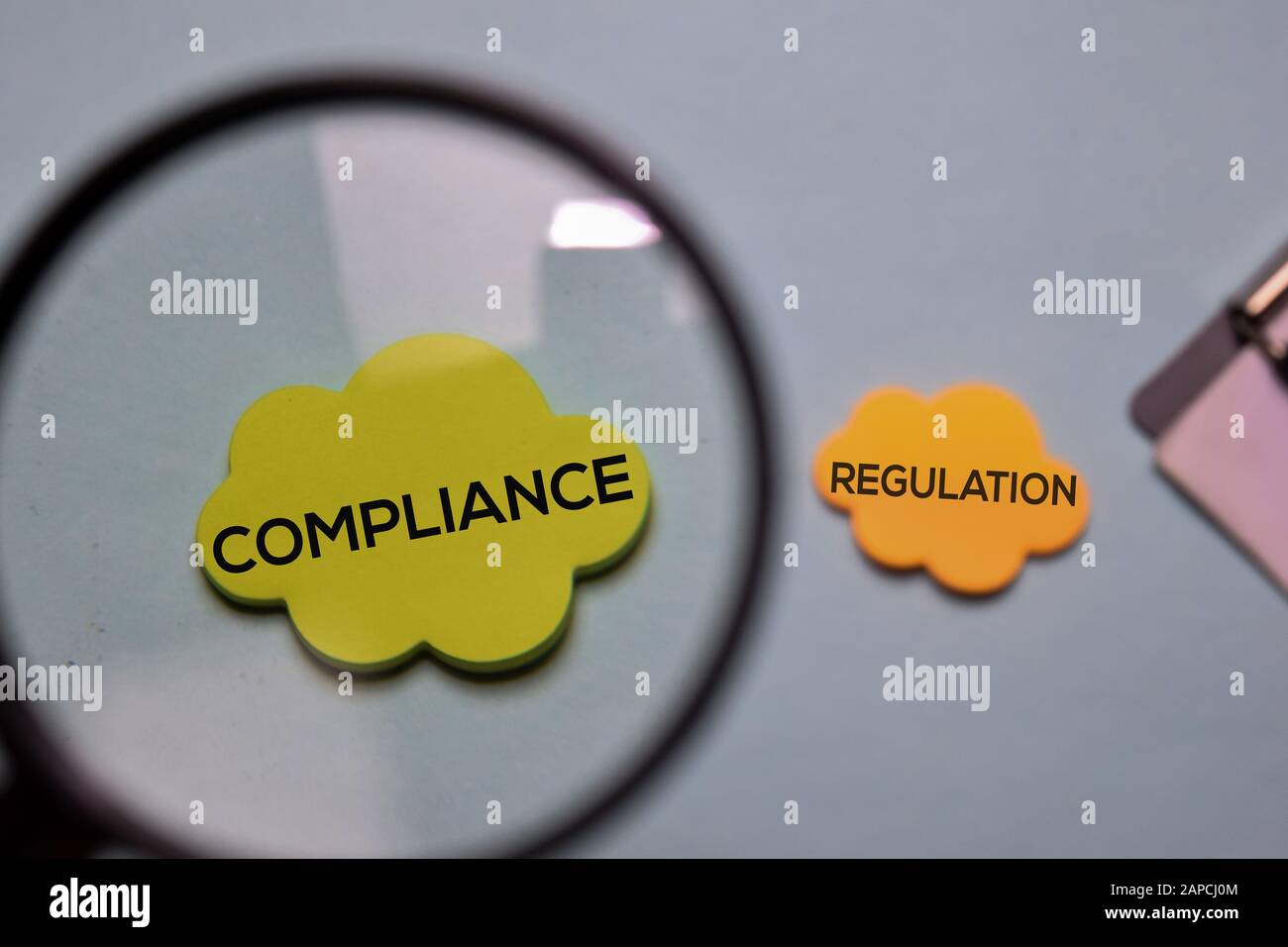 Compliance und Regulierung schreiben Sie auf einen Haftnotiz, der auf dem Schreibtisch isoliert ist. Stockfoto