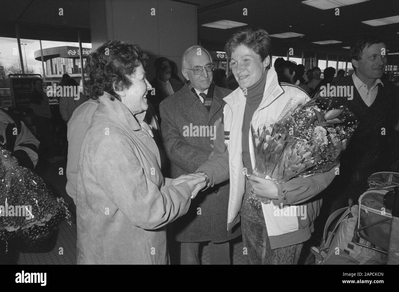 Ankunft Yvonne van Gennip auf Schiphol nach der Weltmeisterschaft in Norwegen; Eltern von Yvonne van Gennip gratulieren der DDR-Weltmeisterin Karin Kania Datum: 14. März 1988 Ort: Noord-Holland, Schiphol Schlüsselwörter: Skating, Name der Sportperson: Kania, Karin Stockfoto