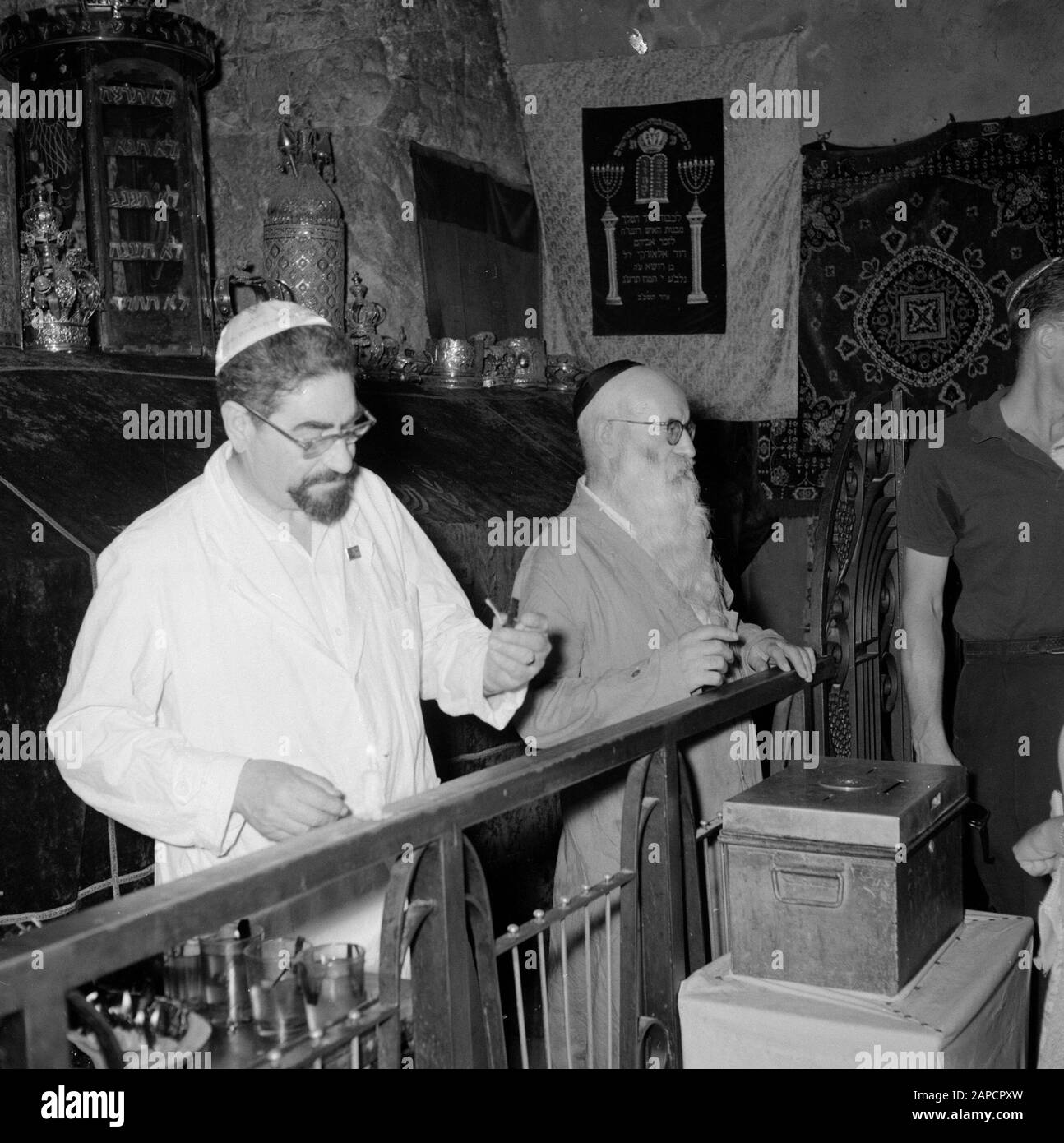 Israel 1964-1965: Jerusalem (Jerusalem), Kirchen und Klöster Beschreibung: Hinter einem Zaun mit dem Rücken zum Grabstein lässt der mutmaßliche Vormund/Gastgeber Anmerkung zu: Das Grab befindet sich im Erdgeschoss und dient heute als Synagoge und Betraum. Der Grabstein ist mit einem Samttuch bedeckt und darauf Tora-Kronen aus Synagogenkreisen jüdischer Gemeinden, der Grabstein selbst hat Aufschriften und Verzierungen aus der Kreuzfahrerzeit. Die Letzte Abendmahlshalle und das Grab Davids befinden sich im selben Gebäude Datum: 1964 Ort: Israel, Jerusalem, Berg Zion Schlüsselwörter: Gräber, Jüdisch Stockfoto