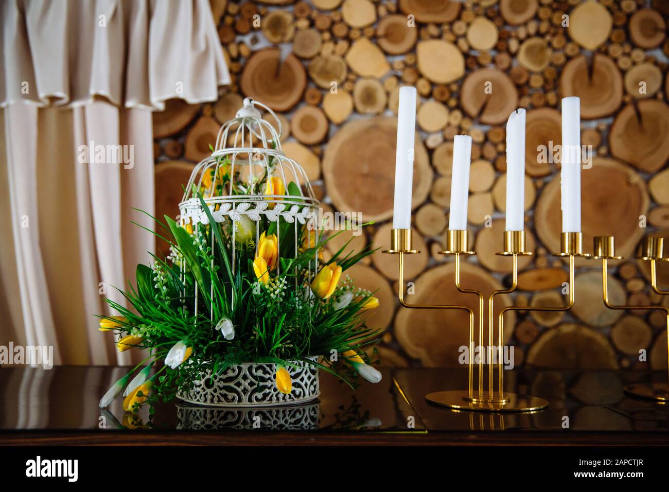 Goldene Kerzenhalter mit Kerzen und Blumen schön auf einen Esstisch gelegt. Stockfoto