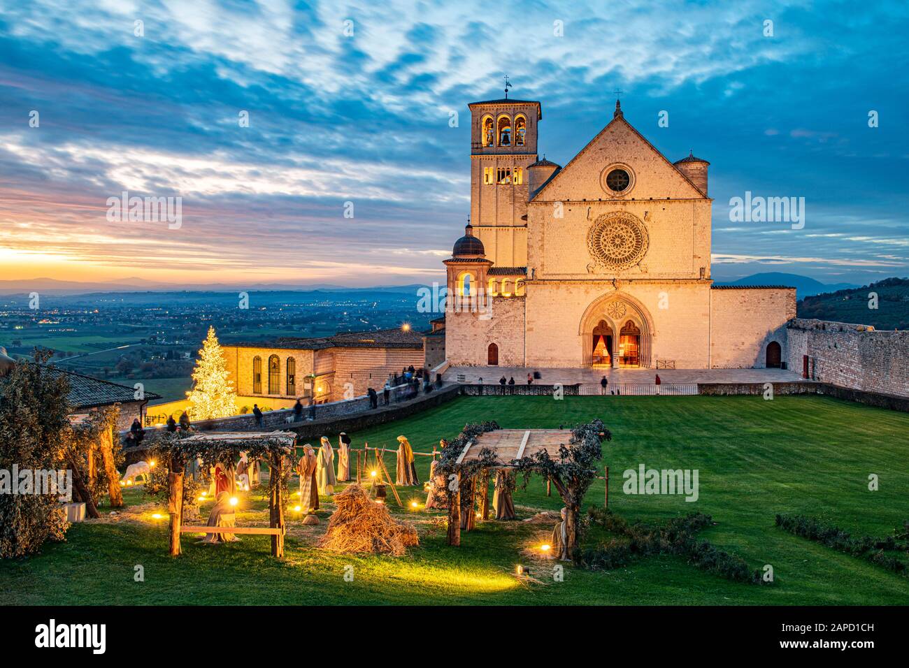 Assisi, Perugia, Umbrien, Italien. Die majestätische Kirche San Francesco, in der der Heilige begraben ist, bei Sonnenuntergang, mit der Krippe draußen während Weihnachten Stockfoto