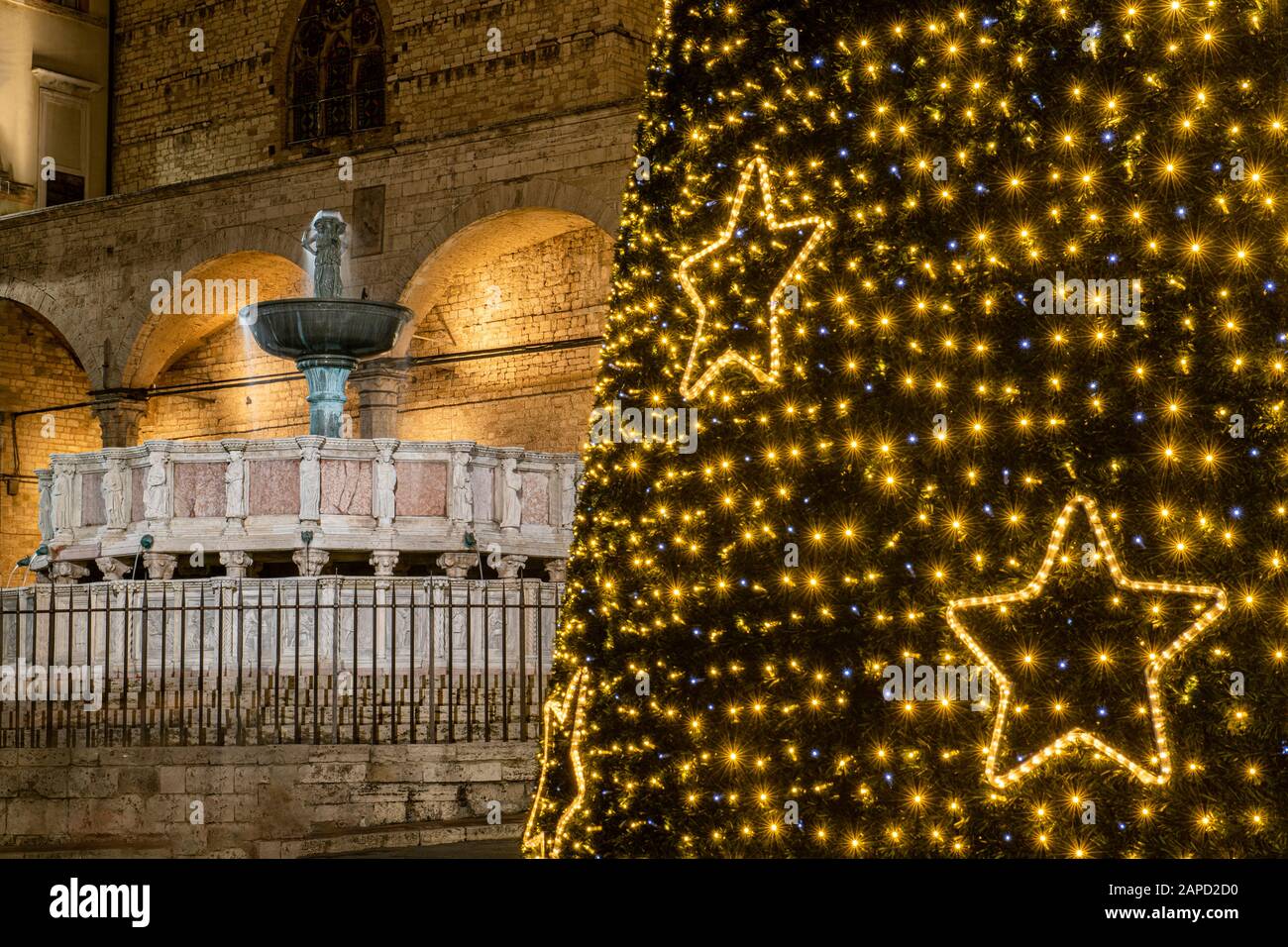 Perugia, Umbrien, Italien. Das Hauptdenkmal der Stadt, die Fontana Maggiore, an der Piazza IV Novembre, mit Weihnachtslichtern und Weihnachtsbaum Stockfoto