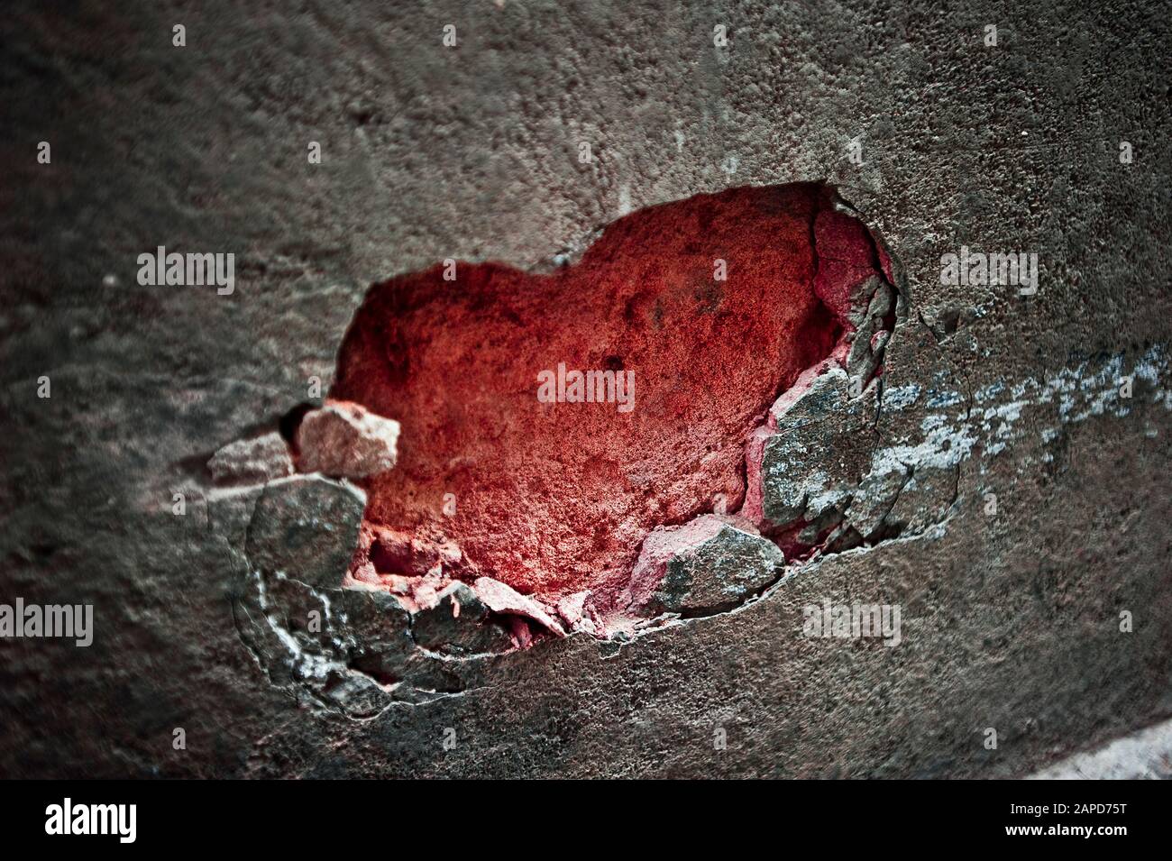 Rote Herzform in Steinwand Stockfoto
