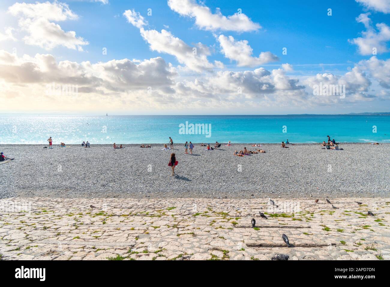 Touristen entspannen am Kieselstrand an der Bucht der Engel an der französischen Riviera in Nizza, Frankreich. Stockfoto