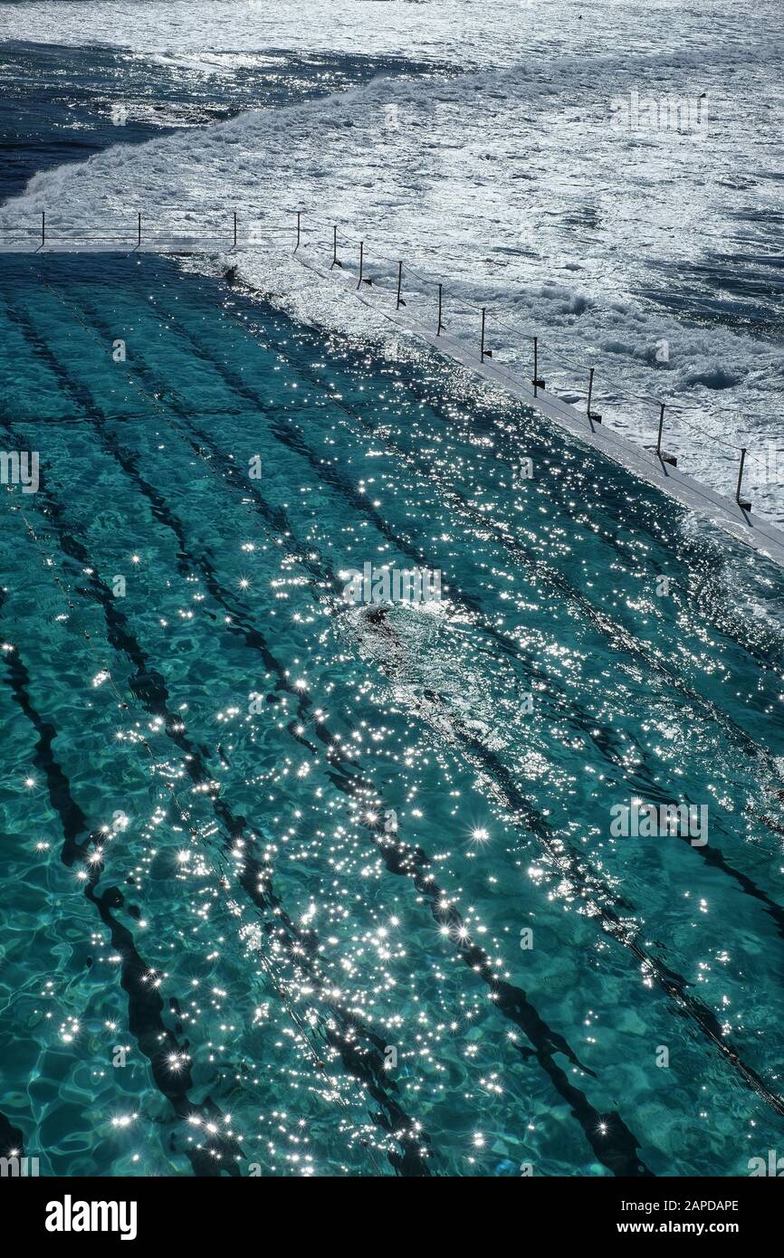 Zwei Runden Schwimmer am berühmten Bondi Eisberg Ozeanpool, in einem schimmernden Ozean und Morgenlicht Stockfoto