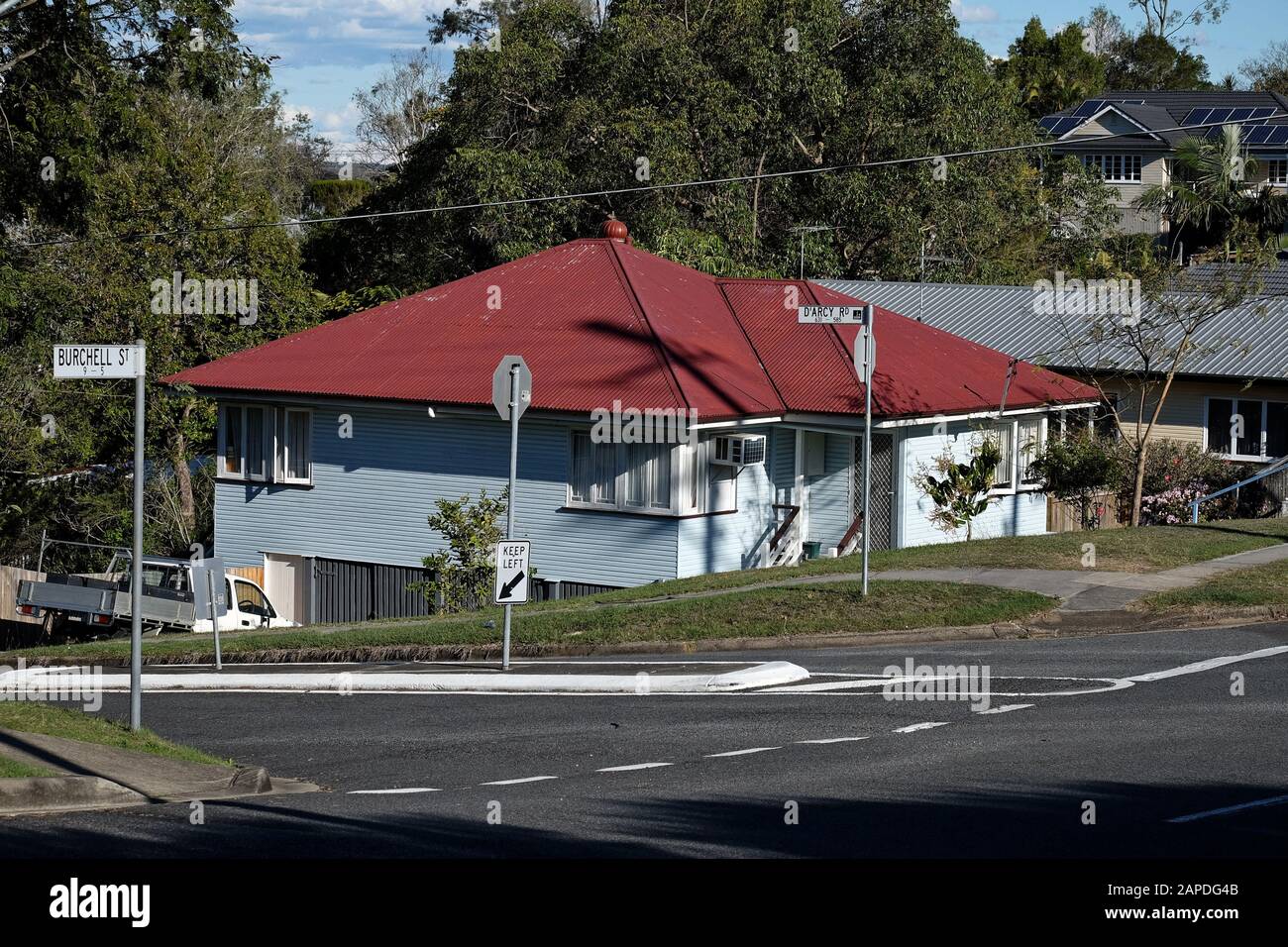 Unterhalb der Fahrbahn versteckt, ein Nahtwetterhaus der Nachkriegsarbeiter mit einem Wellblechdach, Carina, Brisbane Stockfoto