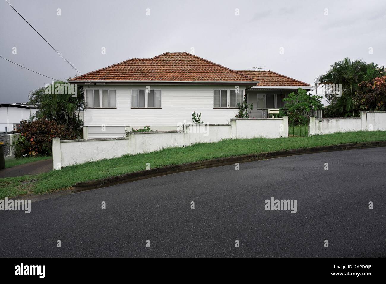 Tidy Post war Wetterhaus mit Ziegeldach und niedrigem Stuck-Zaun, Seven Hills Brisbane Queensland. Stockfoto