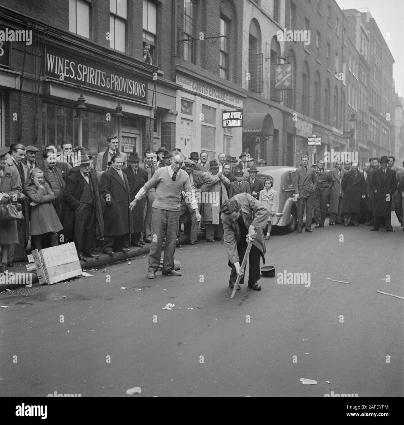 Busker Mad Arthur in Soho, London Beschreibung: Arthur fordert jemanden aus dem Publikum dazu auf, den Trick mit dem Stick Annotation zu machen: "Busker" ist das englische Wort für Straßenmusiker, Straßenkünstler Datum: 1947 Ort: England, London Schlüsselwörter: Öffentlich, Straßenbilder, Theater Stockfoto