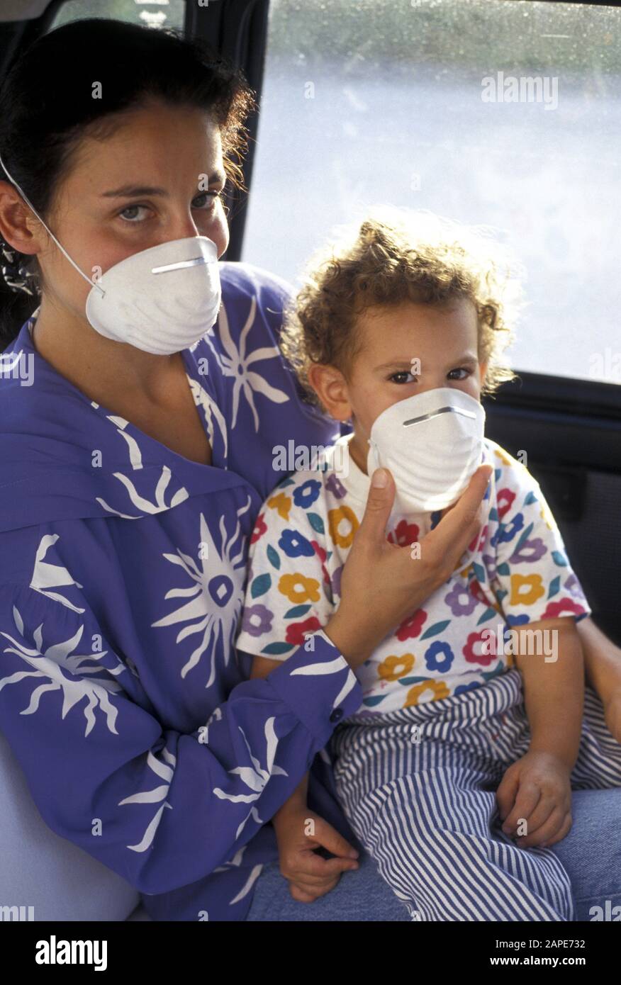 Frau Und Kind Mit Mundschutz Im Auto - Frau und Kind in einem Auto, mit Maske Stockfoto