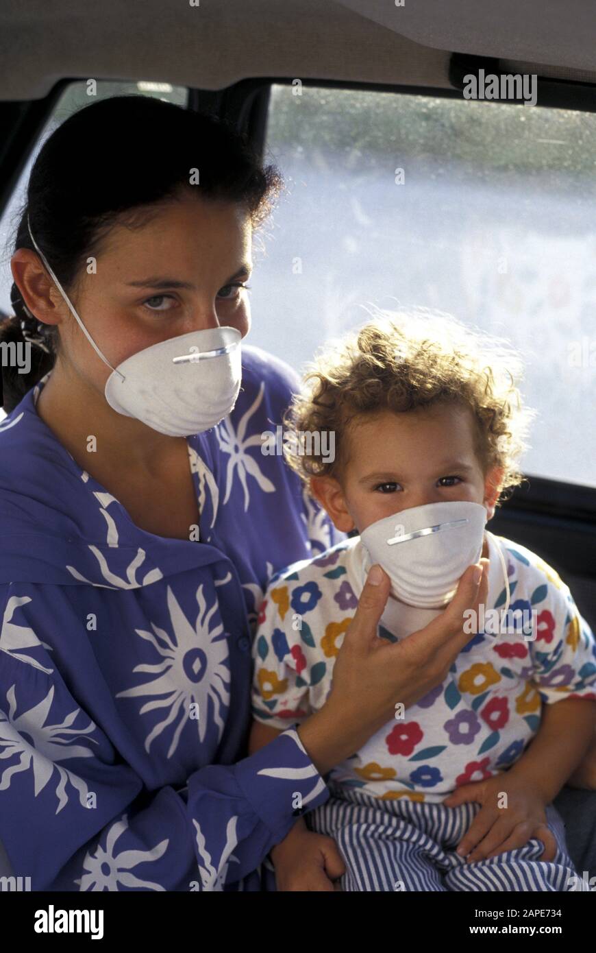 Frau Und Kind Mit Mundschutz Im Auto - Frau und Kind in einem Auto, mit Maske Stockfoto