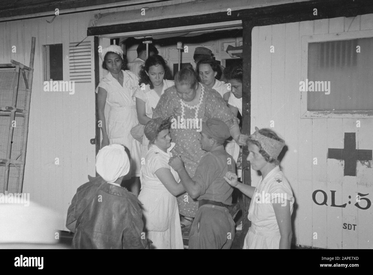 Beschreibung des zweiten Evakuierungs-Tracks der Ankunft: Batavia. Am Bahnhof Manggarai kam ein weiterer Zug mit Familien von aus der republik evakuierten KNIL-Soldaten an. Ein Rotkreuz-Team ging durch die Reise. Glücklicherweise war die Zahl der Kranken jedoch gering. Einige Kranke werden vorsichtig aus dem Zug geladen. Datum: 21.Mai 1948 Ort: Batavia, Indonesien, Jakarta, Niederländisch-Ostindien Stockfoto