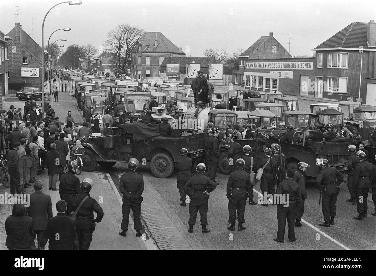 Demonstration der belgischen Landwirte mit Traktoren auf der Straße der Niederlande Beschreibung: Belgische Rijkswacht blockiert Straße Datum: 19. März 1971 Ort: Belgien Schlagwörter: Demonstrationen, Landwirte, Polizisten, Traktoren Stockfoto