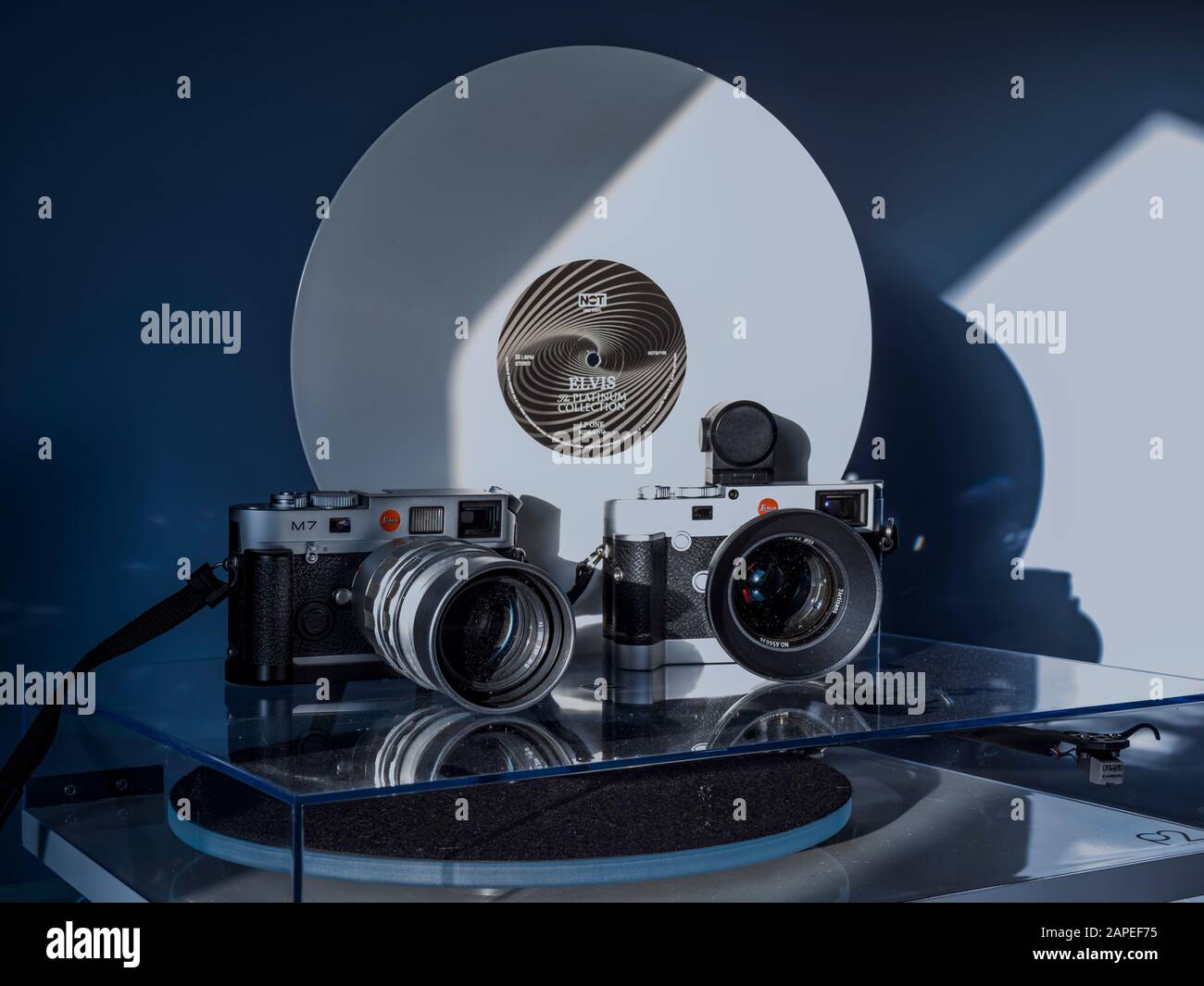 Zwei leica-m-Kameras auf einem Plattendrehtisch mit einer weißen vinyl-elvis-presley-schallplatte dahinter Stockfoto