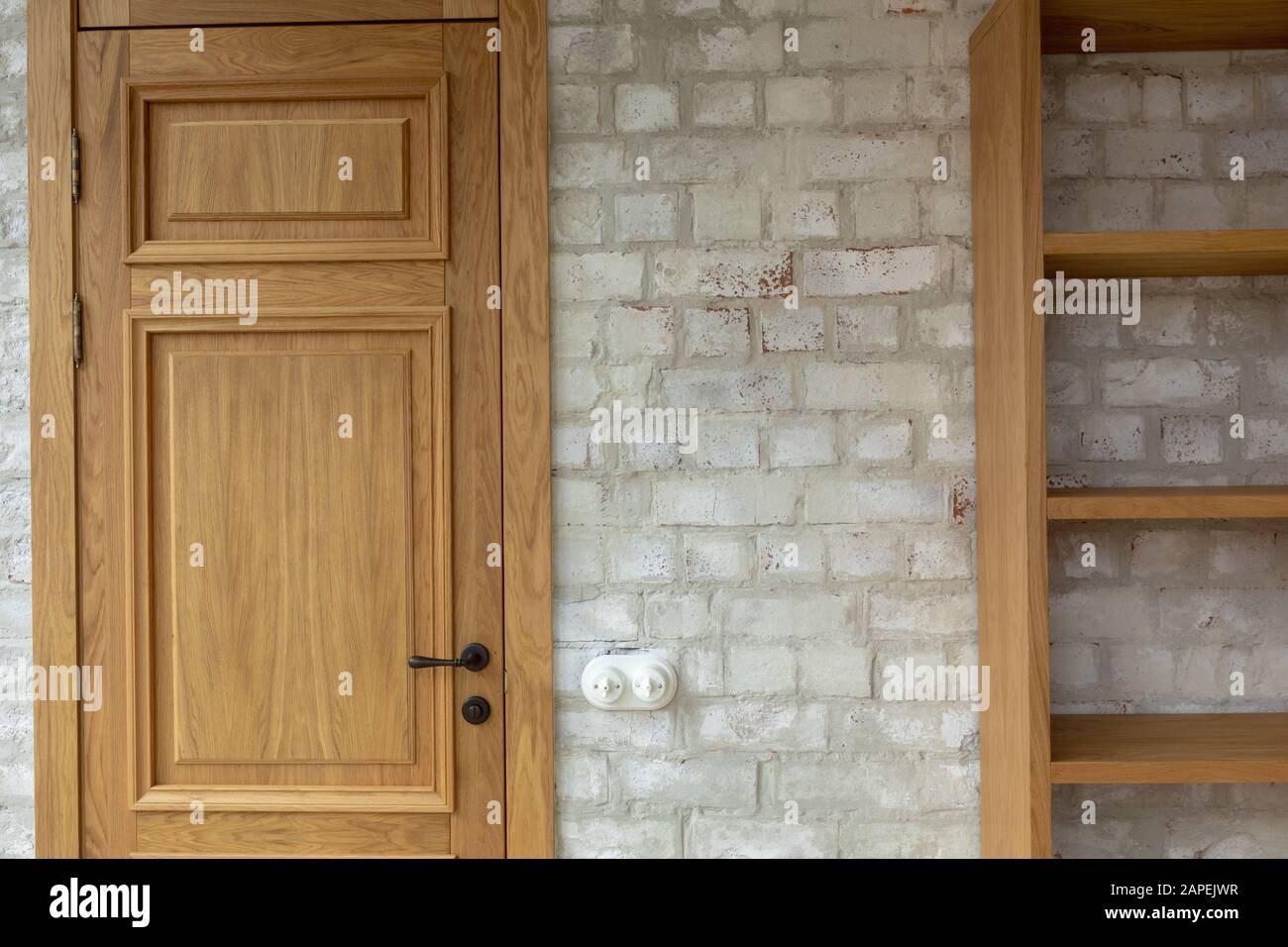 Eiche Tür und Bücherregal gegen weiße Ziegelwand Stockfoto
