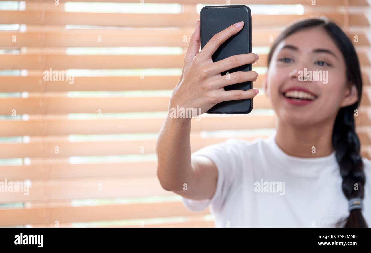 Junge asianerin telefont zu Hause mit dem Smartphone Stockfoto