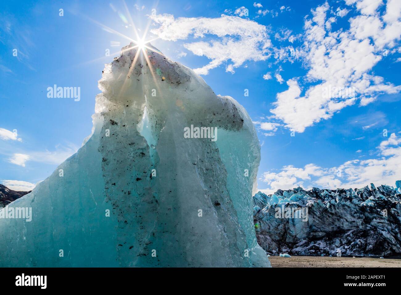 Auf einem gestrandeten eisberg vor dem Lamplugh-Gletscher scheint ein Sonnenaufgang. Stockfoto