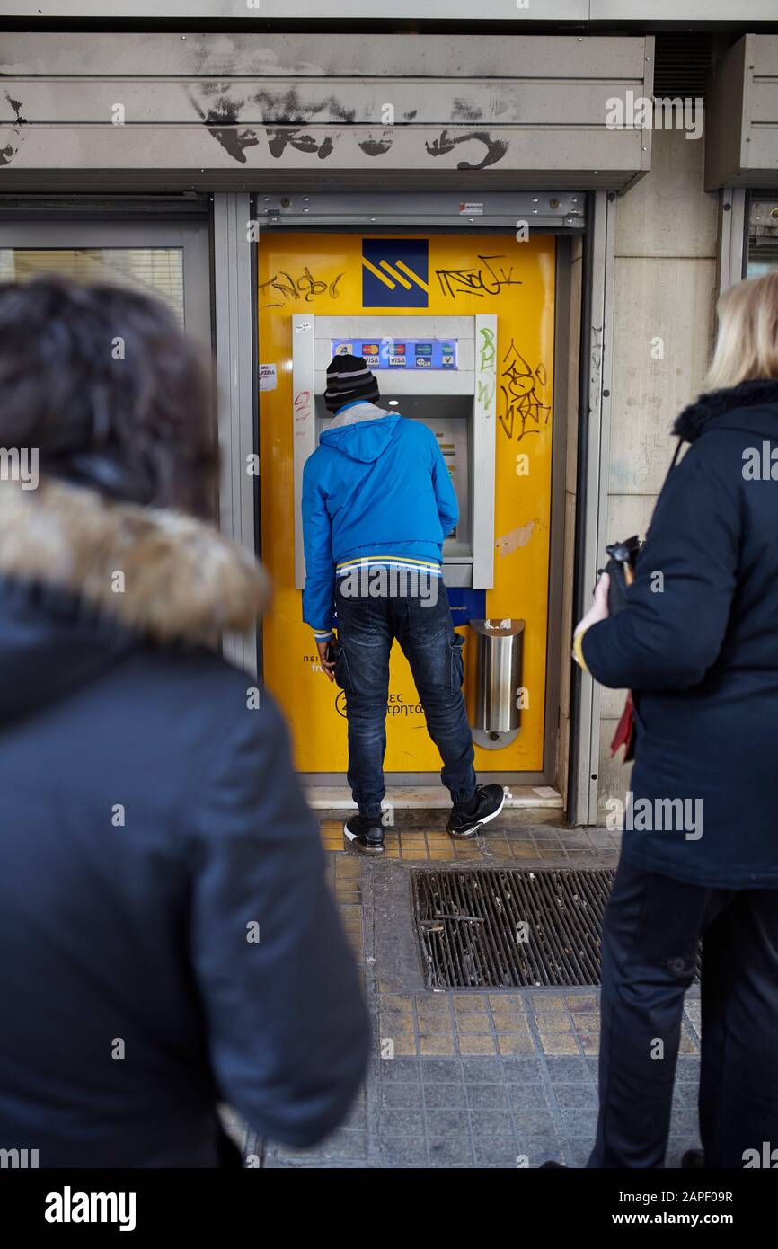 Flüchtling zieht Geld von einer griechischen Bank zurück Stockfoto