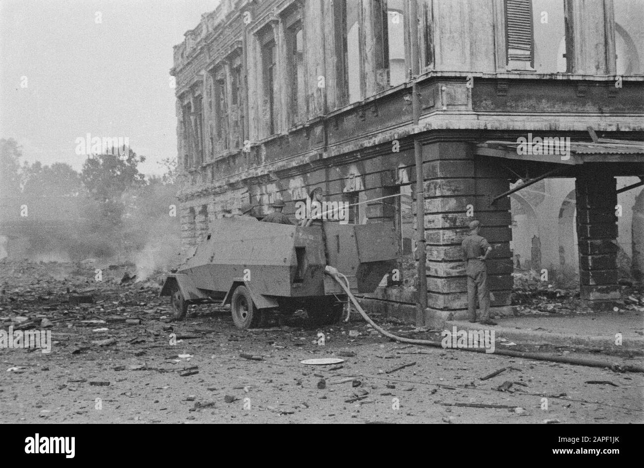 Bandoeng Beschreibung: Löschen eines Feuers in einem zerstörten Bandoeng Datum: 1946 Ort: Bandung, Indonesien, Niederländisch-Ostindien Stockfoto