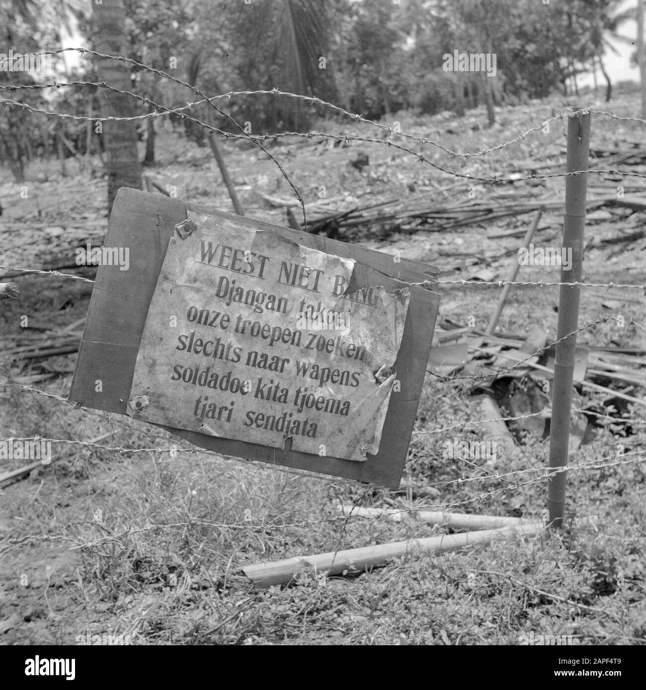 Kriegsfreiwillige in Malakka und Indonesien Beschreibung: Schild an einem Kampong mit der Aufschrift: Keine Angst/Djangan takoet/Unsere Truppen suchen nur Waffen/Soldadoe kita tjari sendiata Datum: März 1946 Ort: Indonesien, Indonesien, Java, Niederländisch-Ostindien Schlüsselwörter: Militär, Barrieren Stockfoto
