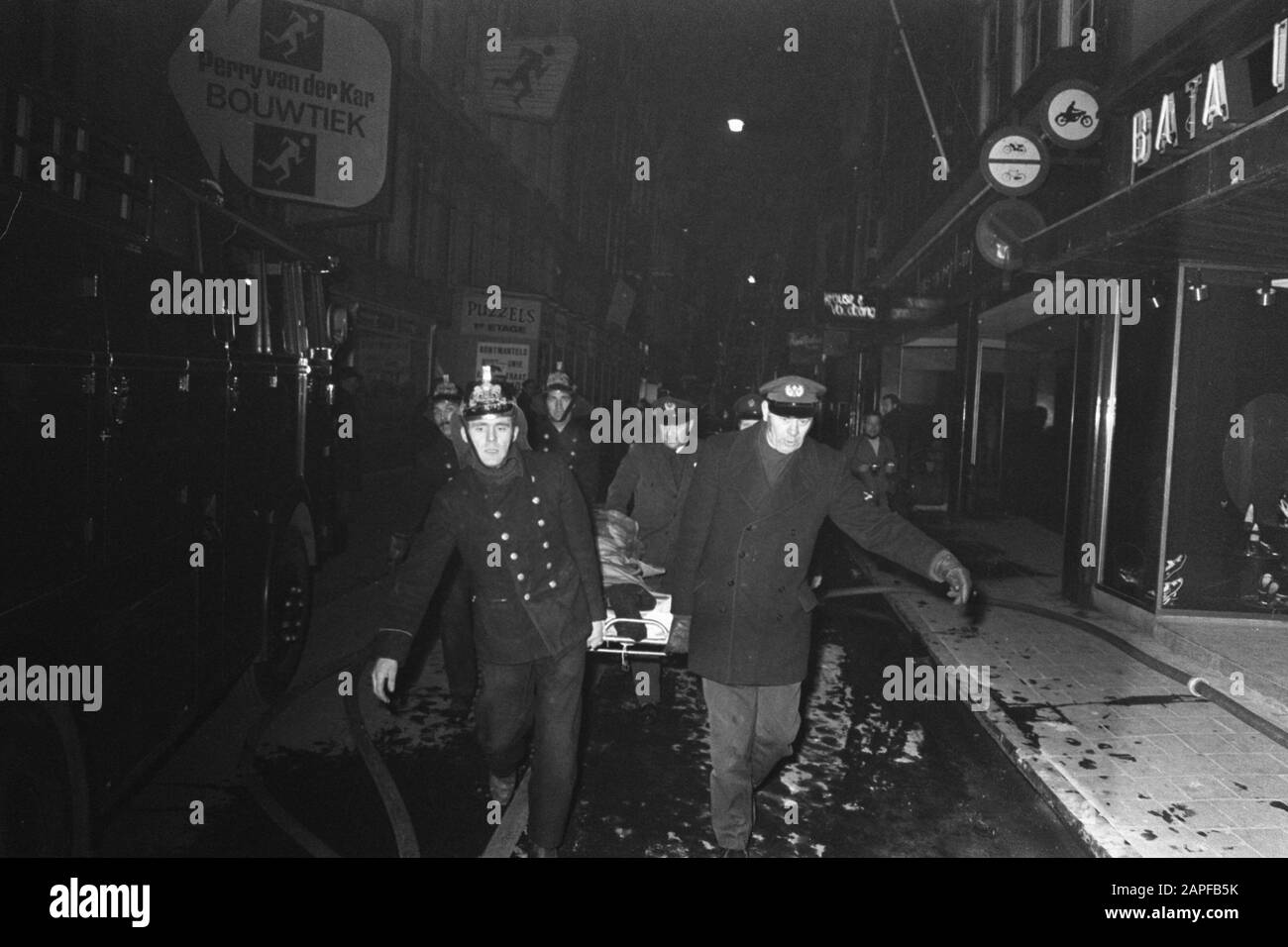 Marke im Modemagazin Krause und Vogelzang in der Kalverstraat Amsterdam. Verletzte werden auf der Bahre im Rettungswagen getragen Datum: 11. März 1970 Ort: Amsterdam, Noord-Holland Schlagwörter: SICKAUS, Trage, Feuer Stockfoto