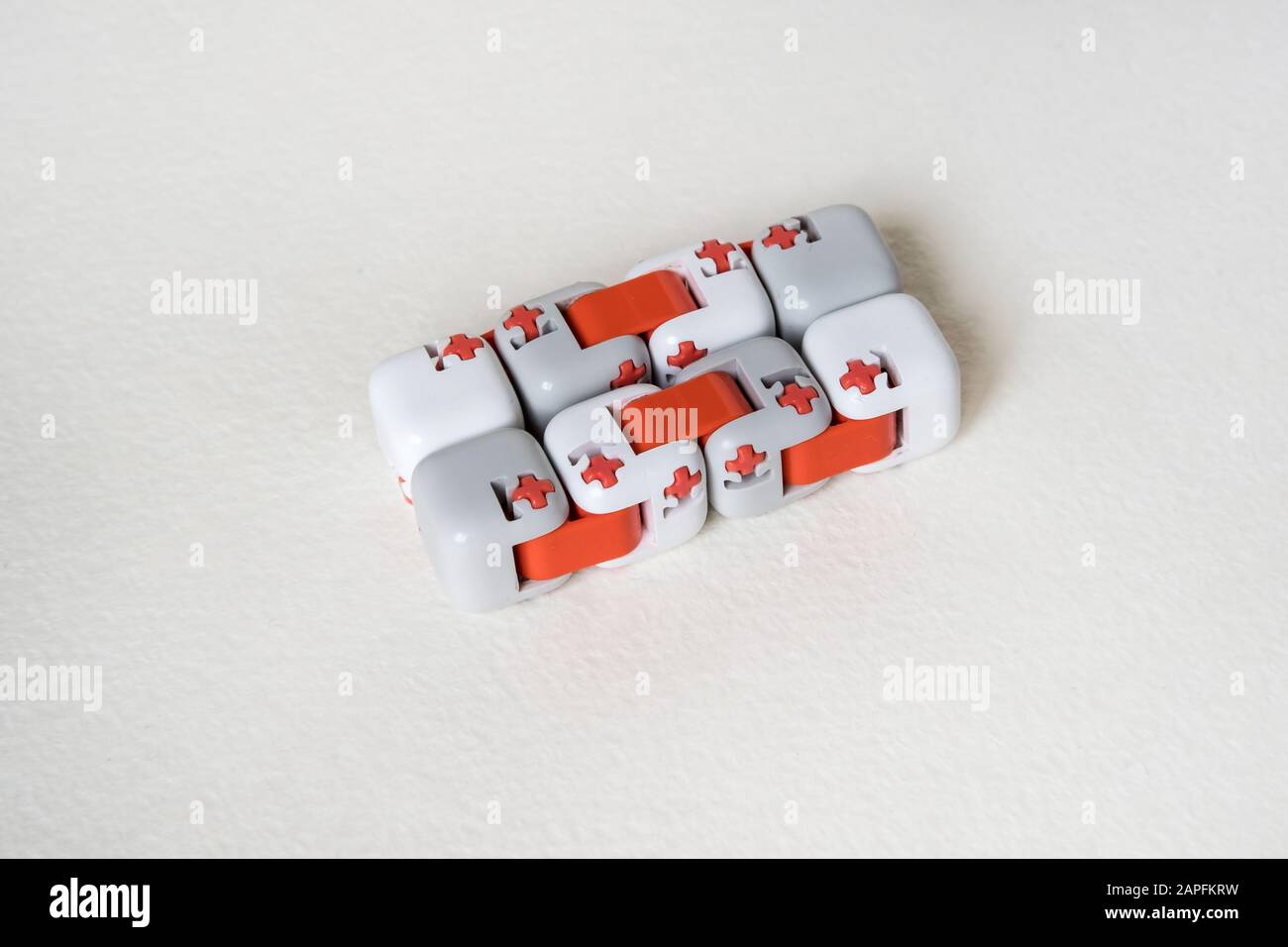 Bunte Finger Antistress Fidget Würfelspielzeug auf weißem Hintergrund. Entwicklung von feinen motorischen Fähigkeiten der Finger von Kindern Stockfoto