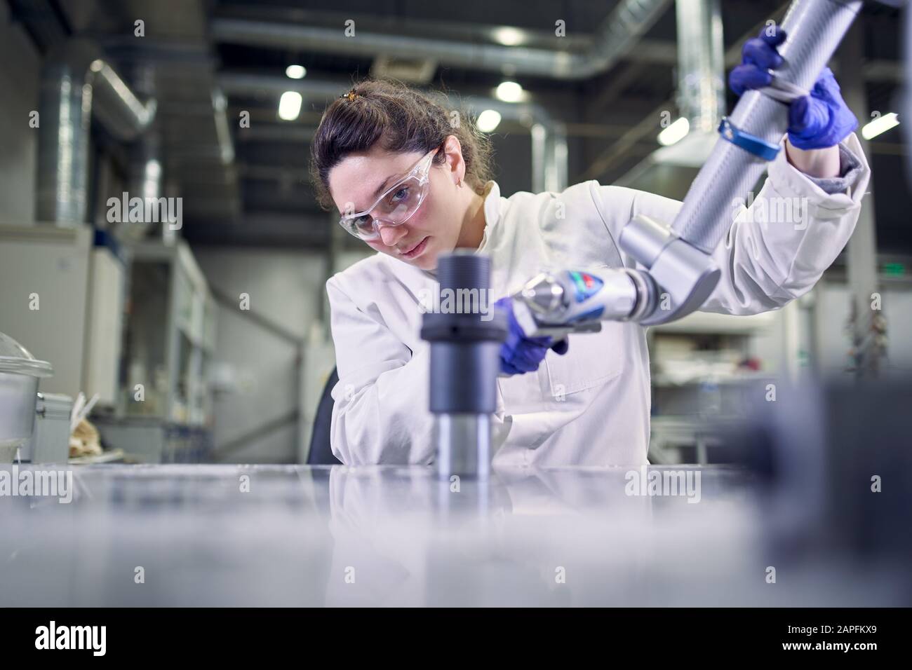 Laborassistentin in weißem Mantel mit 3D-Drucker auf verschwommenem Hintergrund, neue Technologien Stockfoto