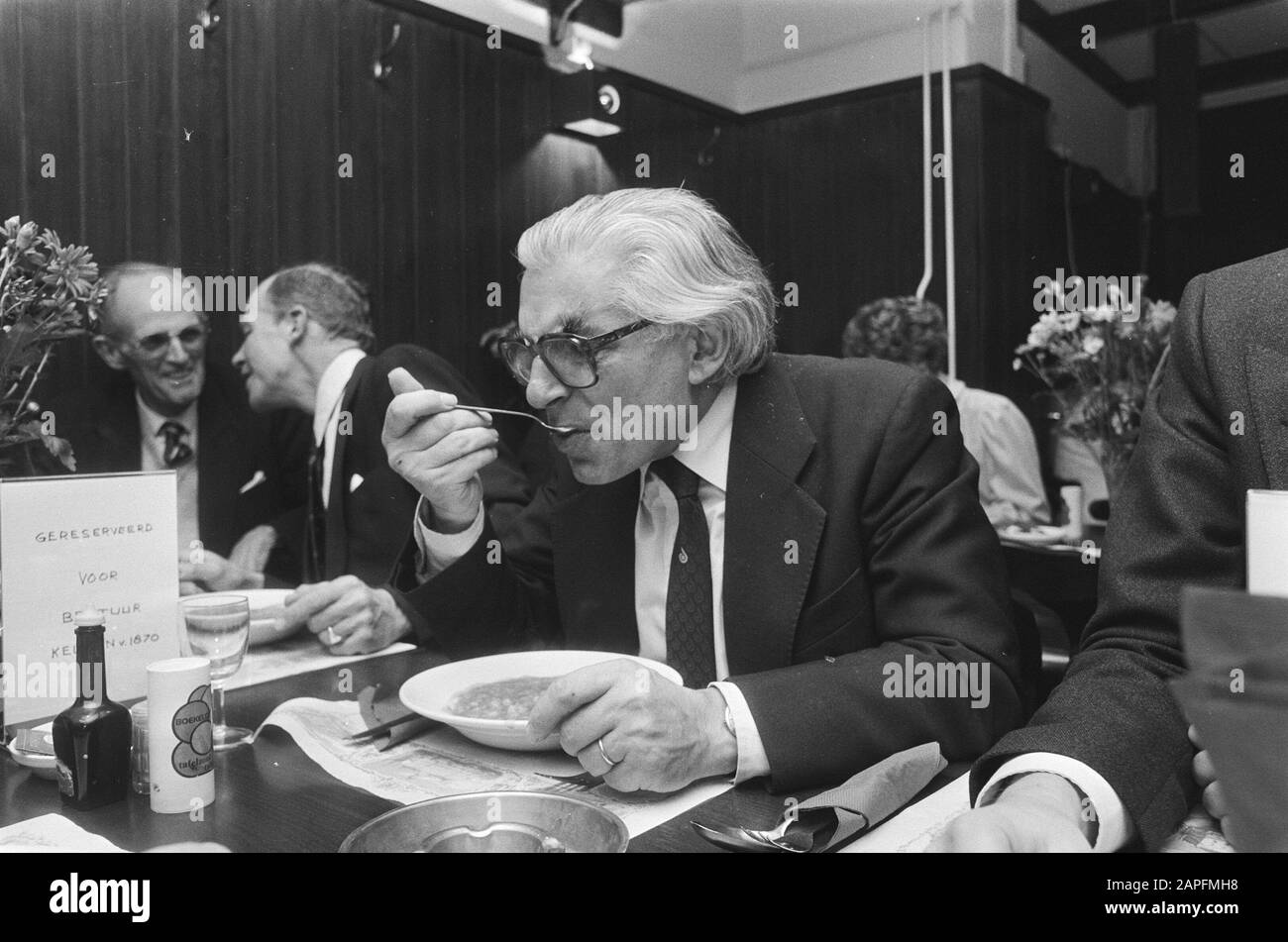 Burgemeester Polak eröffnet Restaurant The Kitchen of 1870, die ehemalige Folksuppenküche in der Spuistraat in Amsterdam Beschreibung: Bürgermeister Polak isst einen Teller mit Erbsensuppe Datum: 15. November 1982 Ort: Amsterdam, Noord-Holland Schlüsselwörter: Bürgermeister, Mahlzeiten, Restaurants, Volksküchen persönlicher Name: Polak, Wim Stockfoto