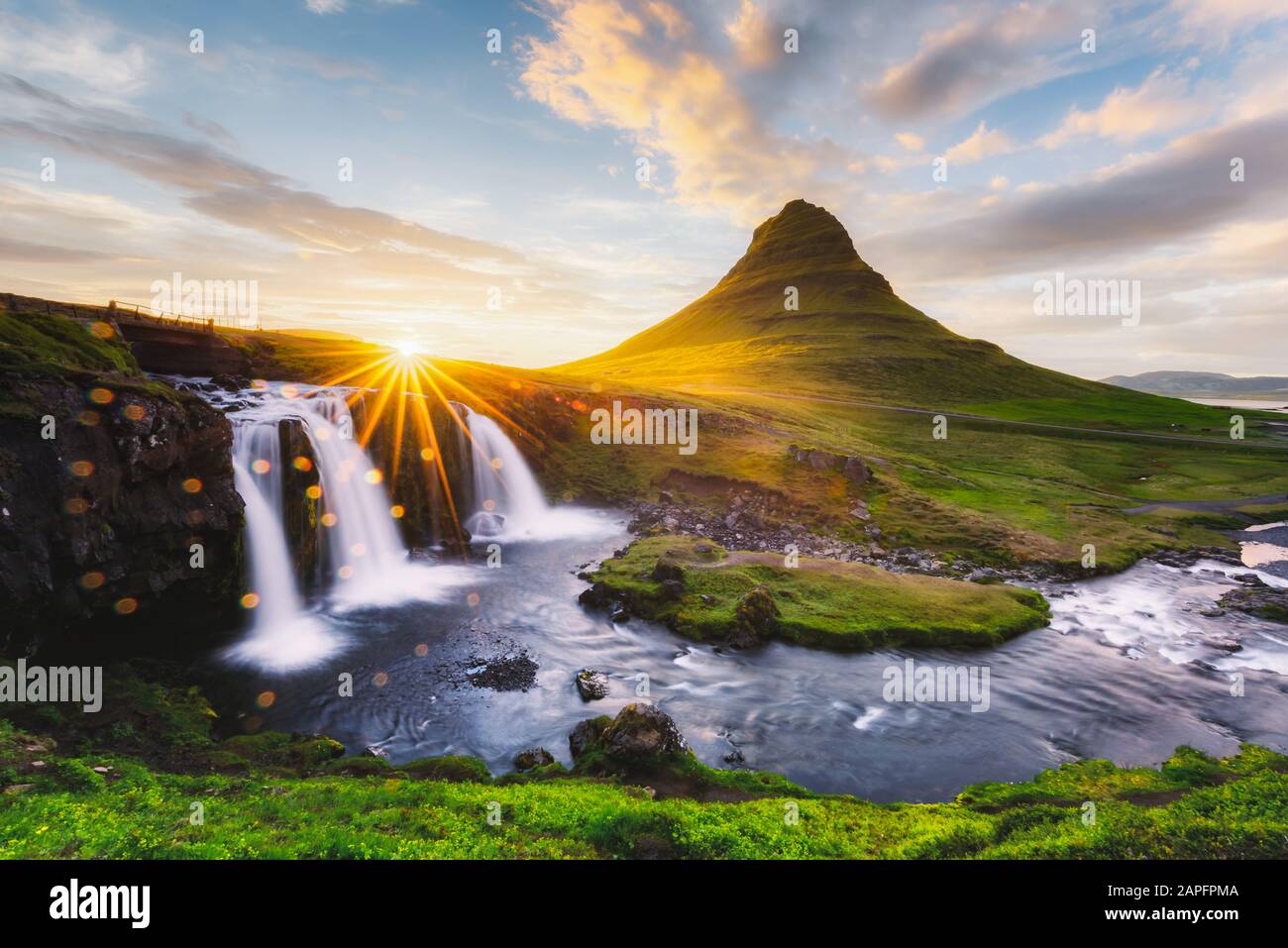 Morgenlandschaft mit aufsteigender Sonne am Wasserfall Kirkjufellsfoss und am Berg Kirkjufell, Island, Europa. Landschaftsfotografie Stockfoto