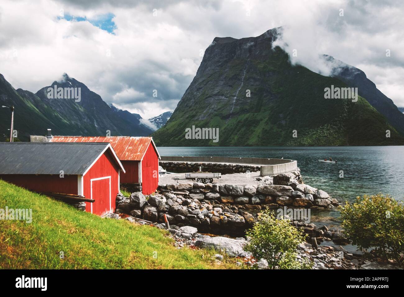 Malerische Szene des Dorfes Urke und des Fjords Hjorundfjord, Norwegen. Drammatischer Himmel und düstere Berge. Landschaftsfotografie Stockfoto