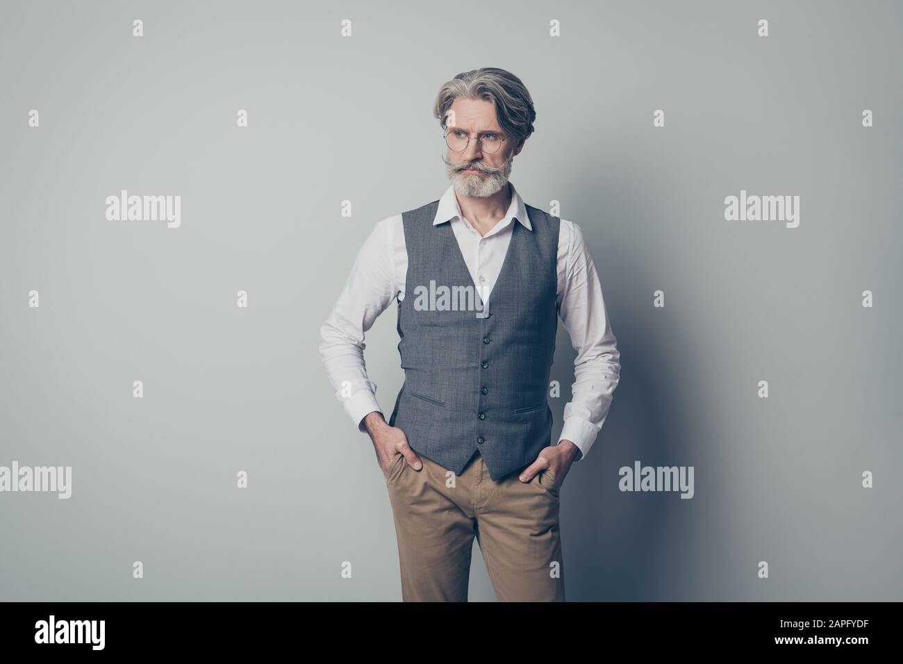 Foto eines gealterten Macho-Geschäftmanns strenger Boss ernsthaft aussehen leer Raum hören Kollegen tragen Spezifikationen Büro weiße Hemdweste Hose isoliert auf Stockfoto