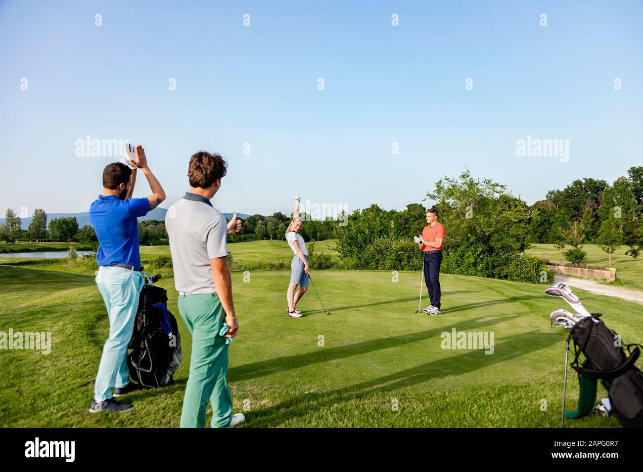 Freunde, die auf dem Golfplatz Golf spielen Stockfoto